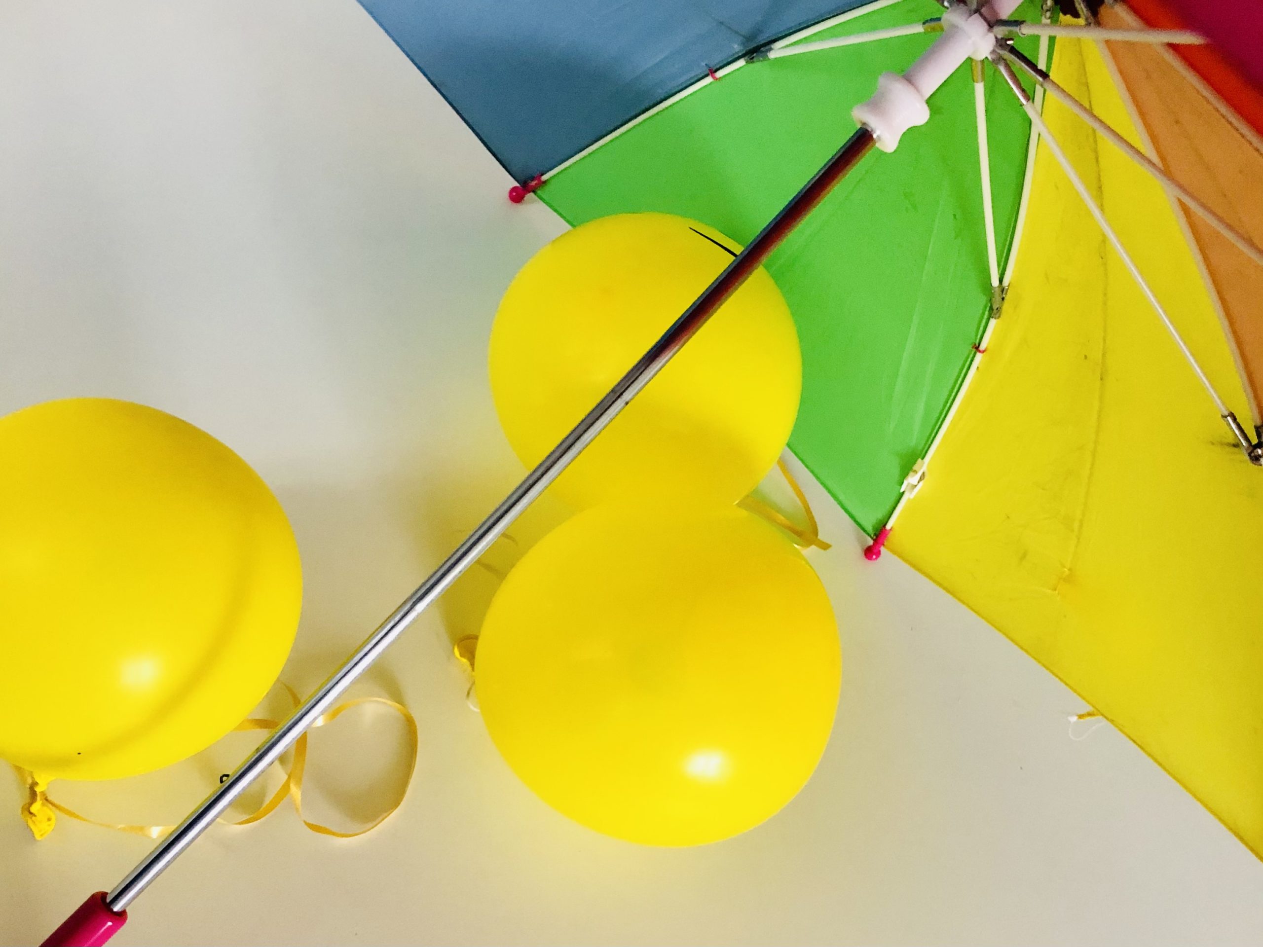 Bild zum Schritt 3 für das Bastel- und DIY-Abenteuer für Kinder: 'Nun hängt ihr die Luftballons an die Stangen des Regenschirms....'