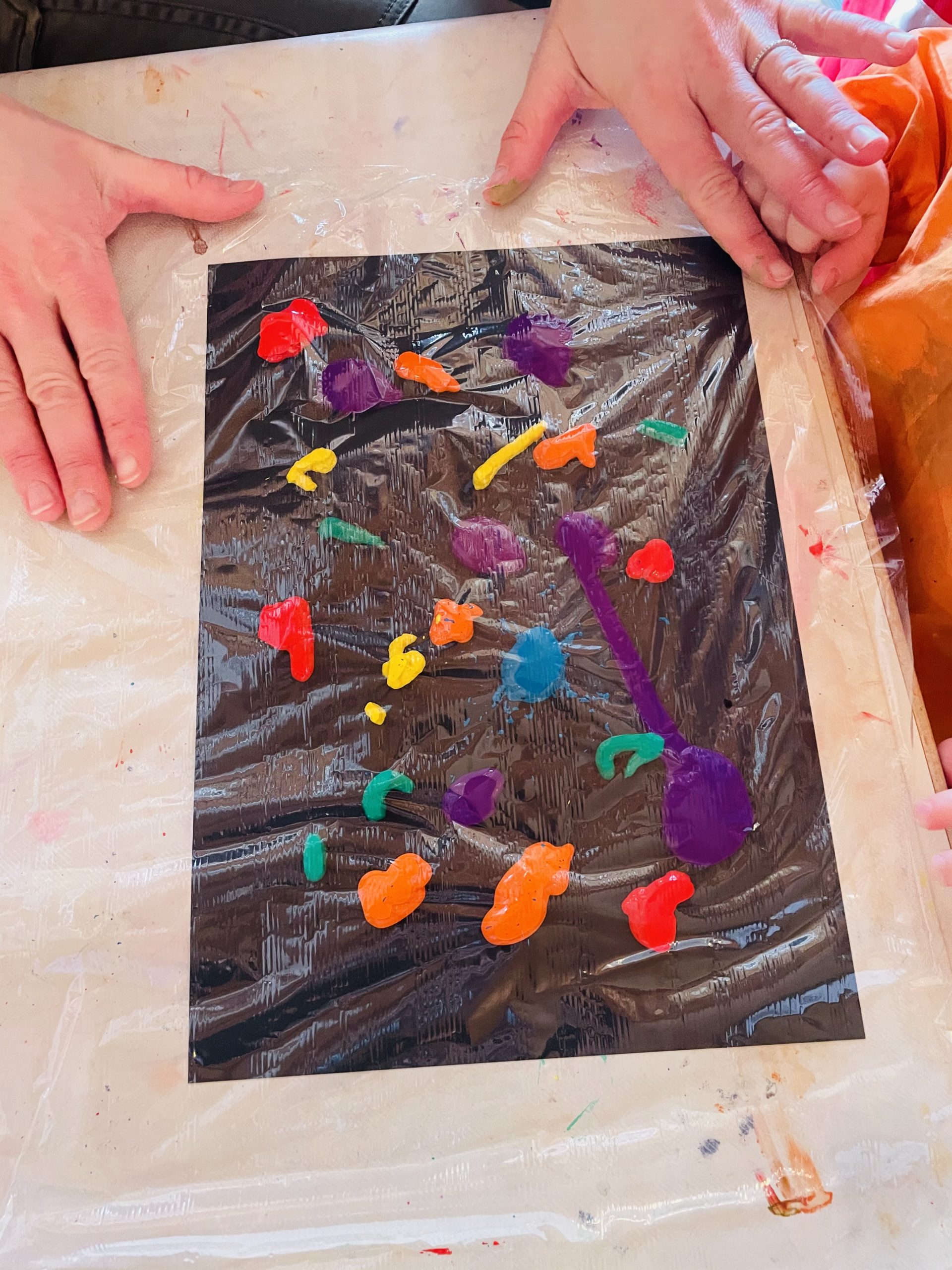 Bild zum Schritt 2 für das Bastel- und DIY-Abenteuer für Kinder: 'Legt anschließend sofort eine Frischhaltefolie über die Farbkleckse., diese muss...'