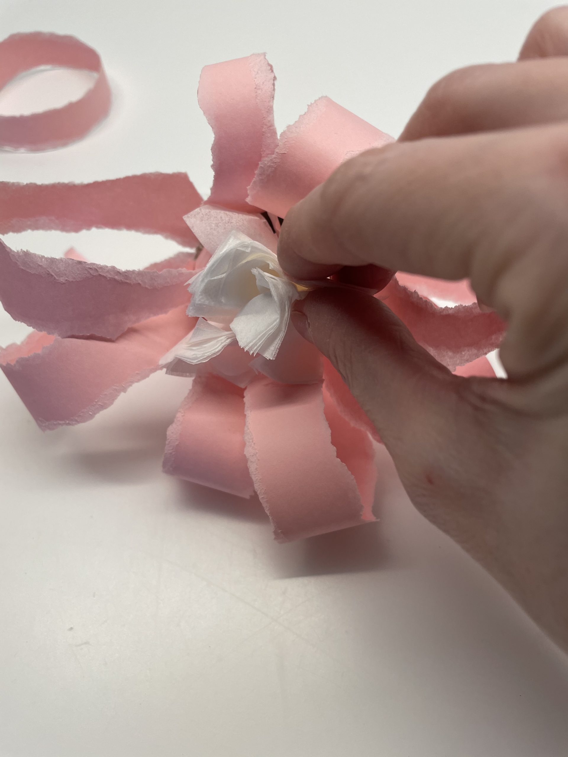 Bild zum Schritt 25 für das Bastel- und DIY-Abenteuer für Kinder: 'Anschließend steckt ihr das Taschentuch in den Blütenkelch.'