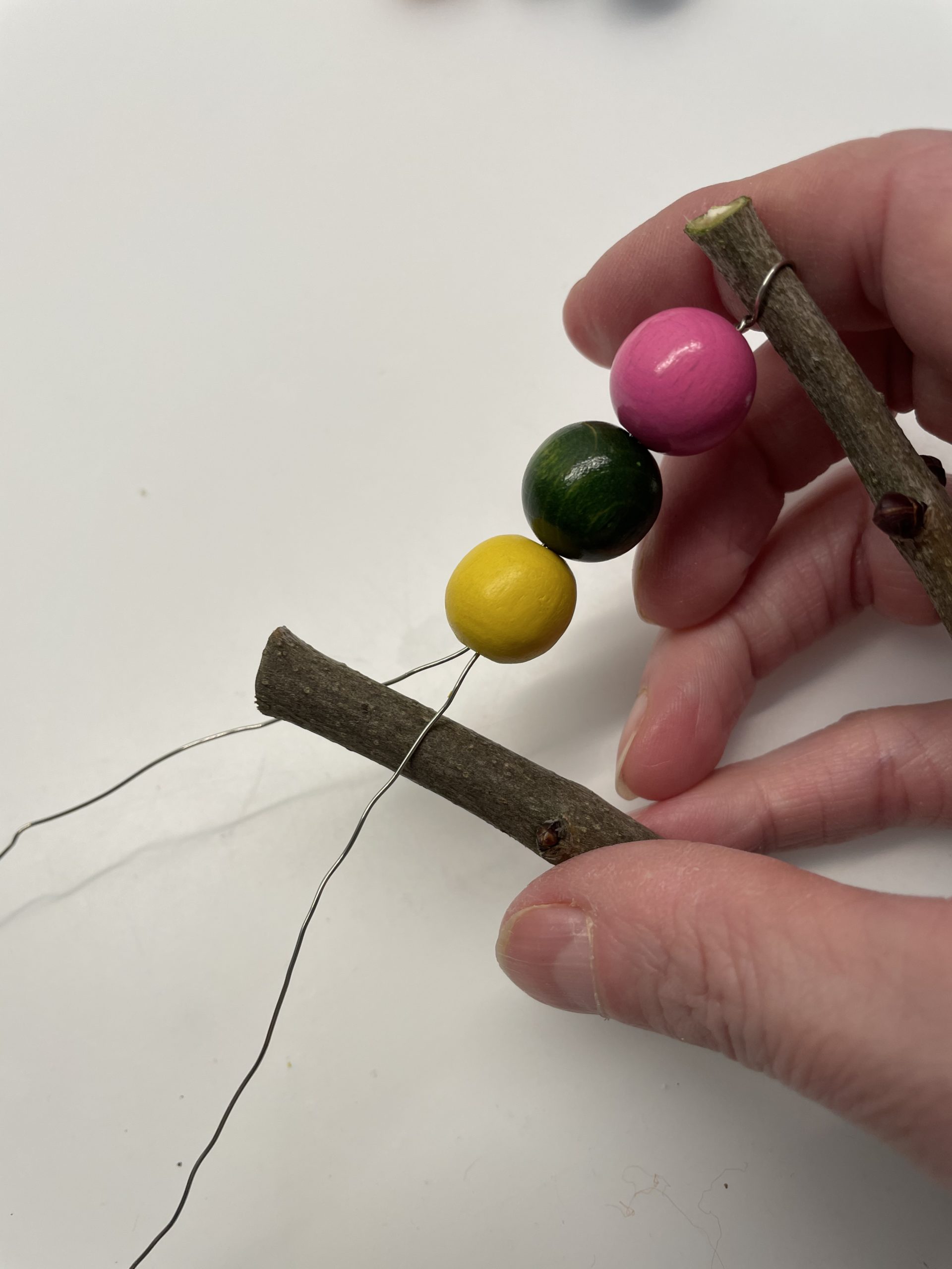 Bild zum Schritt 6 für das Bastel- und DIY-Abenteuer für Kinder: 'Fädelt so viele Perlen auf den Draht, dass sich die...'