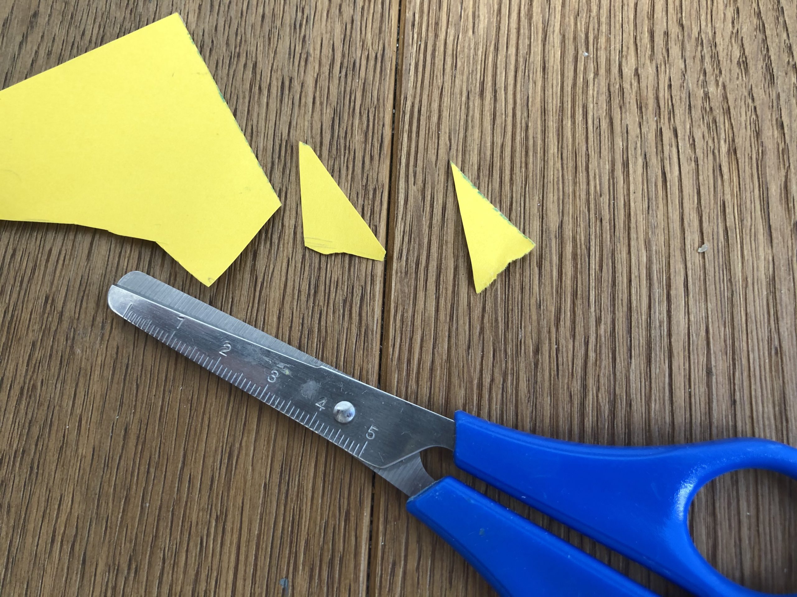 Bild zum Schritt 3 für das Bastel- und DIY-Abenteuer für Kinder: 'Aus einem gelben Rest Tonpapier schneidet ihr nun den Schnabel...'