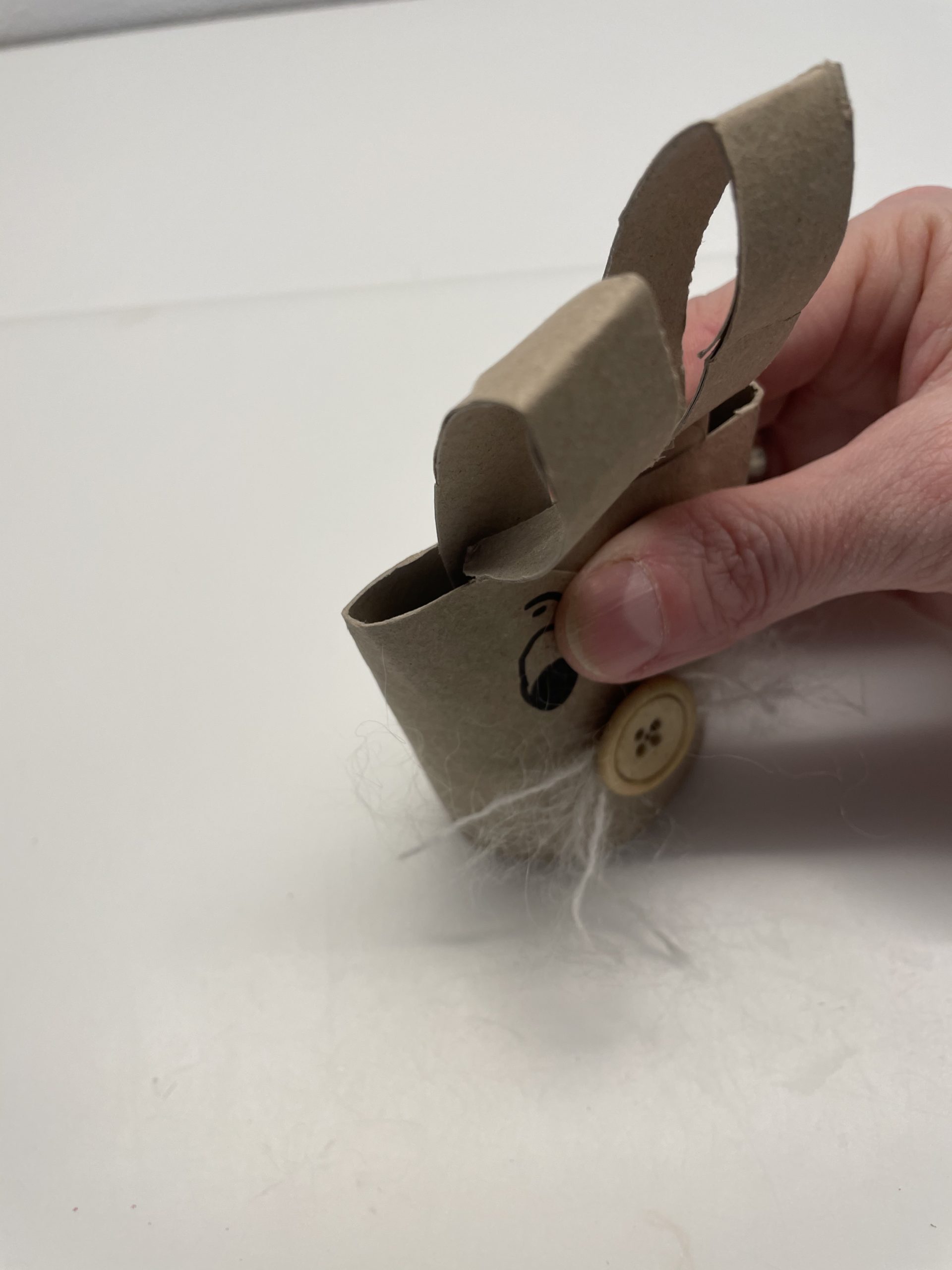 Bild zum Schritt 19 für das Bastel- und DIY-Abenteuer für Kinder: 'Drückt dafür jetzt die Papprolle oben bei den Ohren flach...'