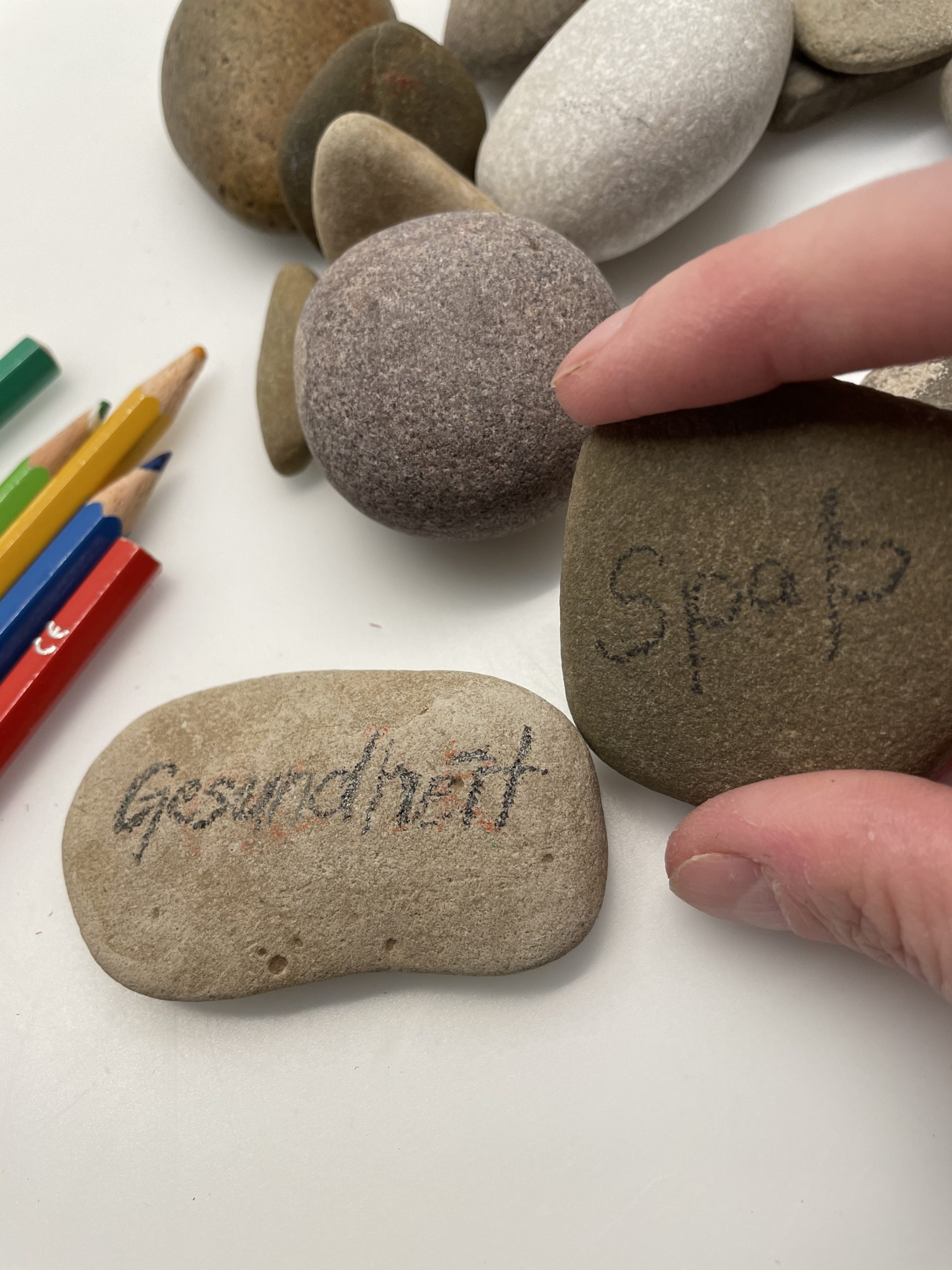 2. Bild zum Schritt 4 für das Bastel- und DIY-Abenteuer für Kinder: 'Mit Buntstiften könnt ihr auf die Steine schreiben.'