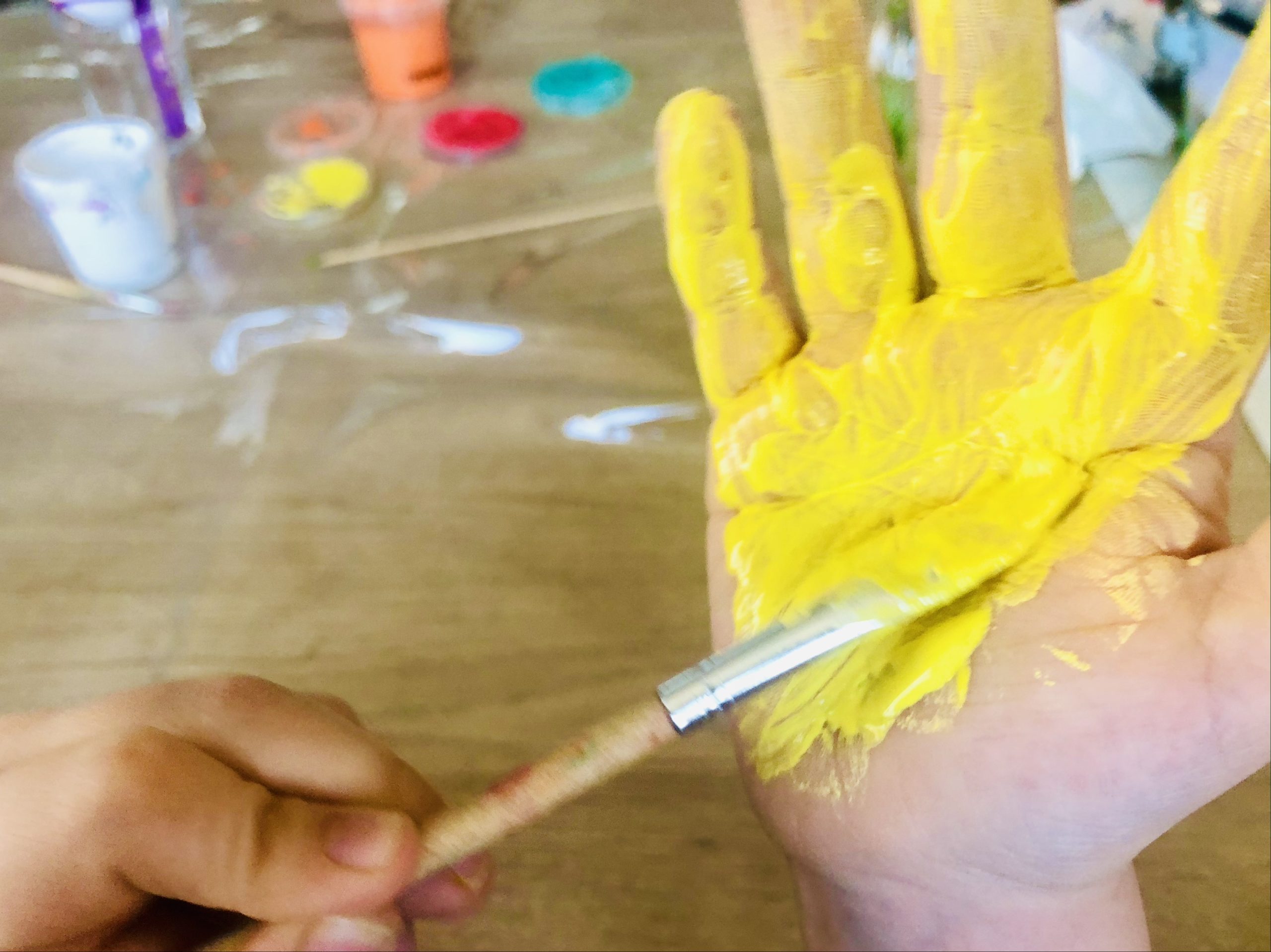 Bild zum Schritt 11 für die Kinder-Beschäftigung: 'Hierfür malt ihr ebenfalls eine Hand mit gelber Fingerfarbe an.'