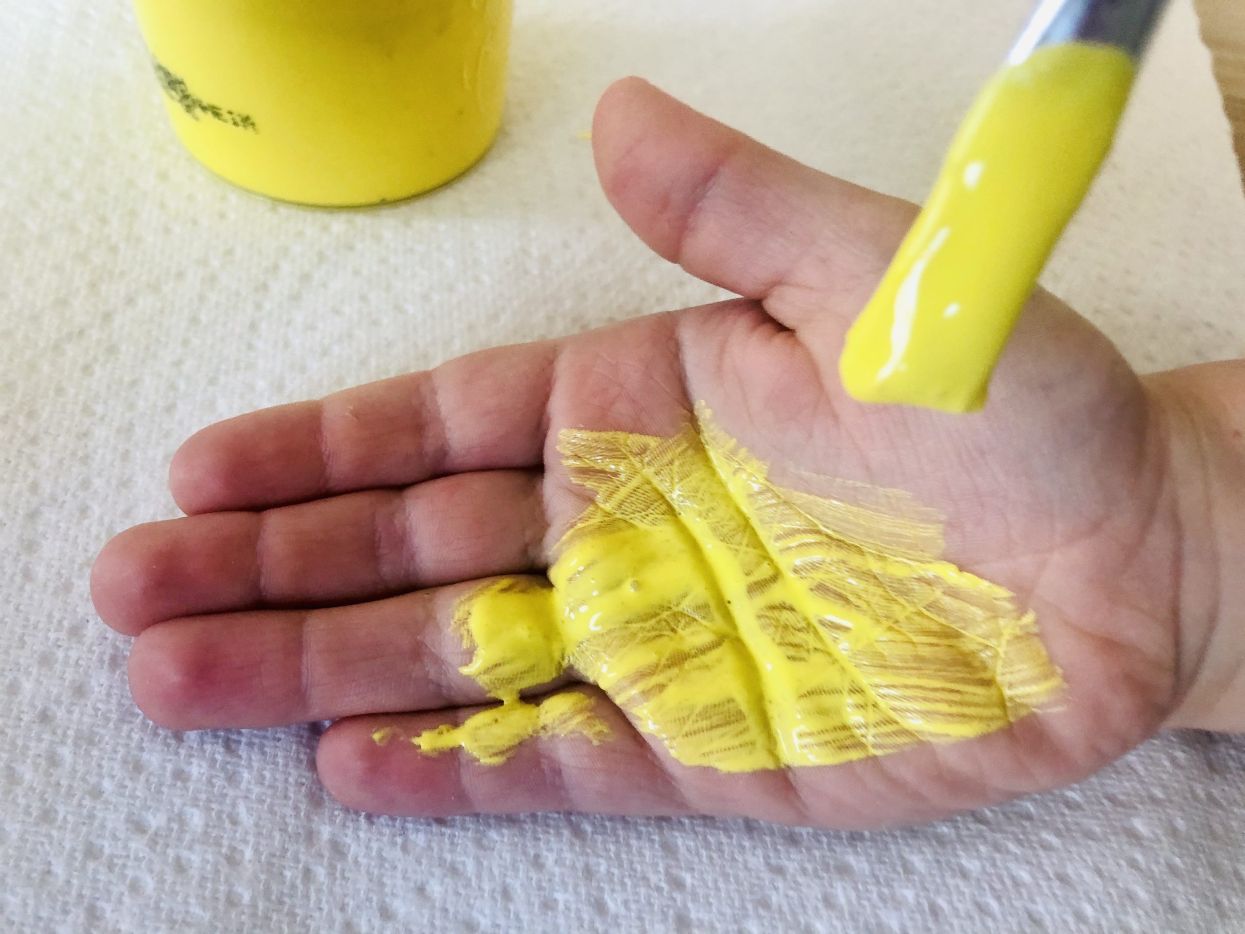 Bild zum Schritt 2 für das Bastel- und DIY-Abenteuer für Kinder: 'Dann beginnt ihr mit dem Pinsel gelbe Fingerfarbe auf eine...'