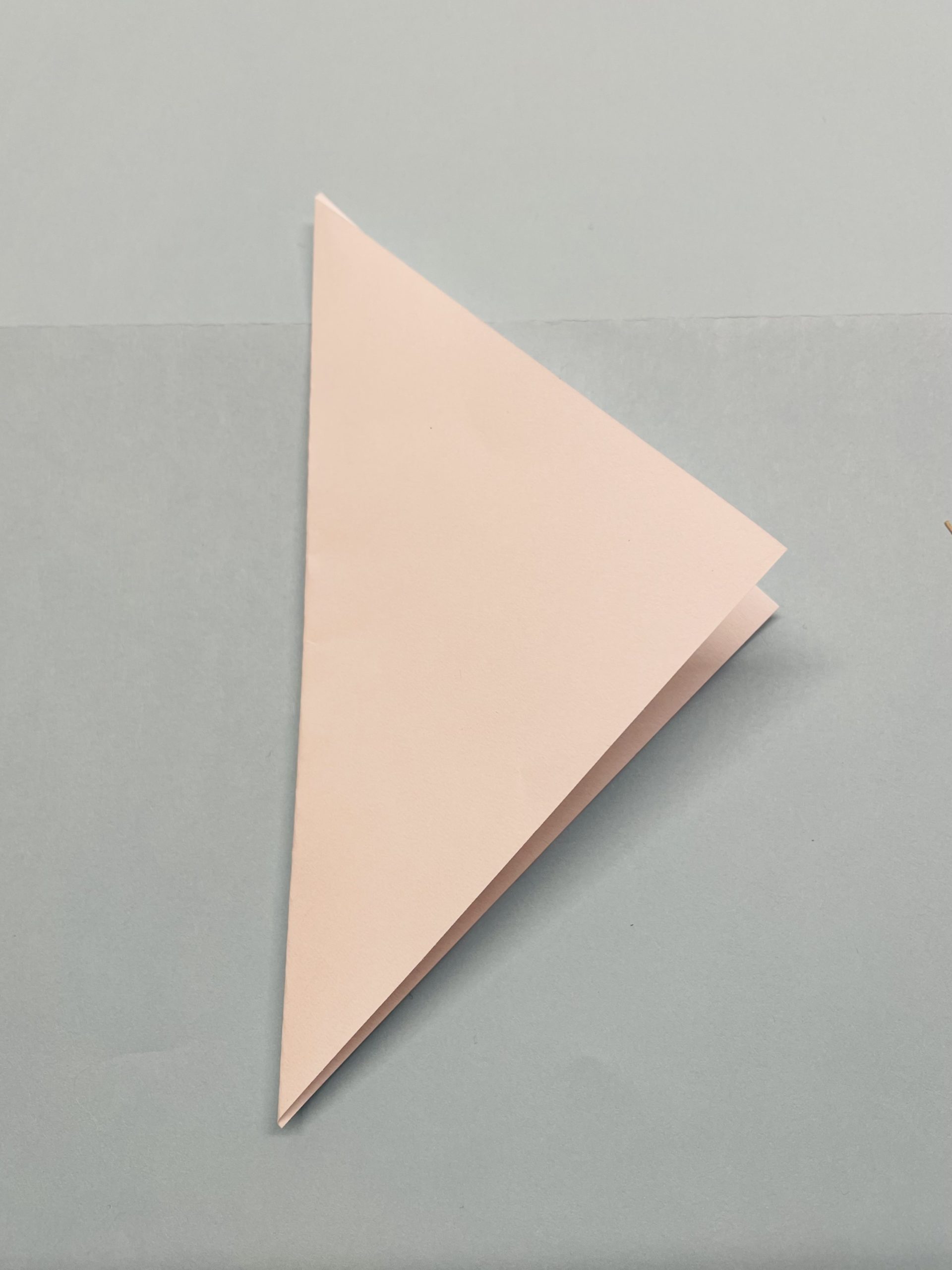 Bild zum Schritt 8 für das Bastel- und DIY-Abenteuer für Kinder: 'Dreht das Dreieck so, dass eine Spitze zu euch zeigt.'