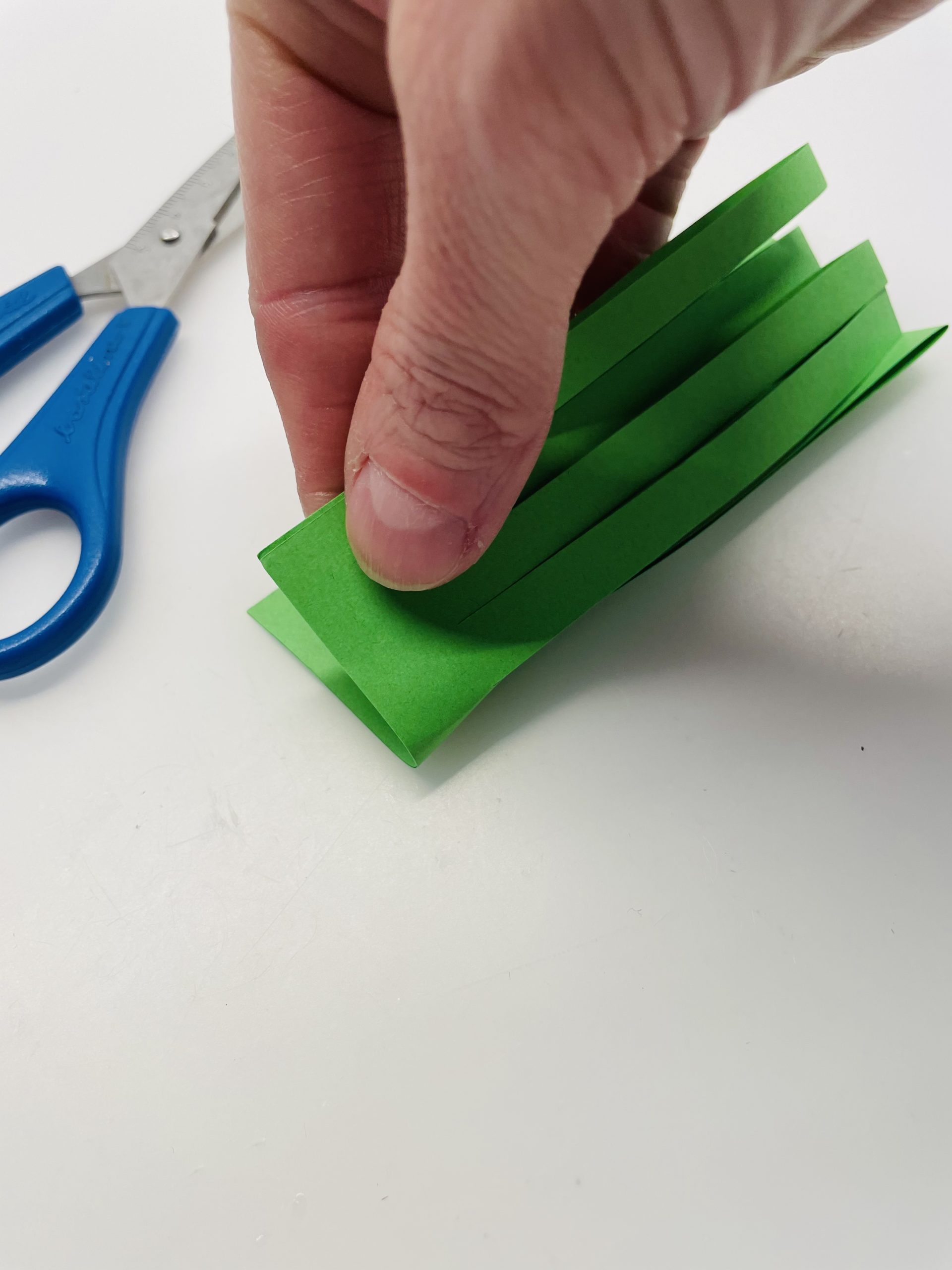 Bild zum Schritt 16 für das Bastel- und DIY-Abenteuer für Kinder: 'Faltet das geschnittene Papier nun zur Hälfte. So liegen die...'
