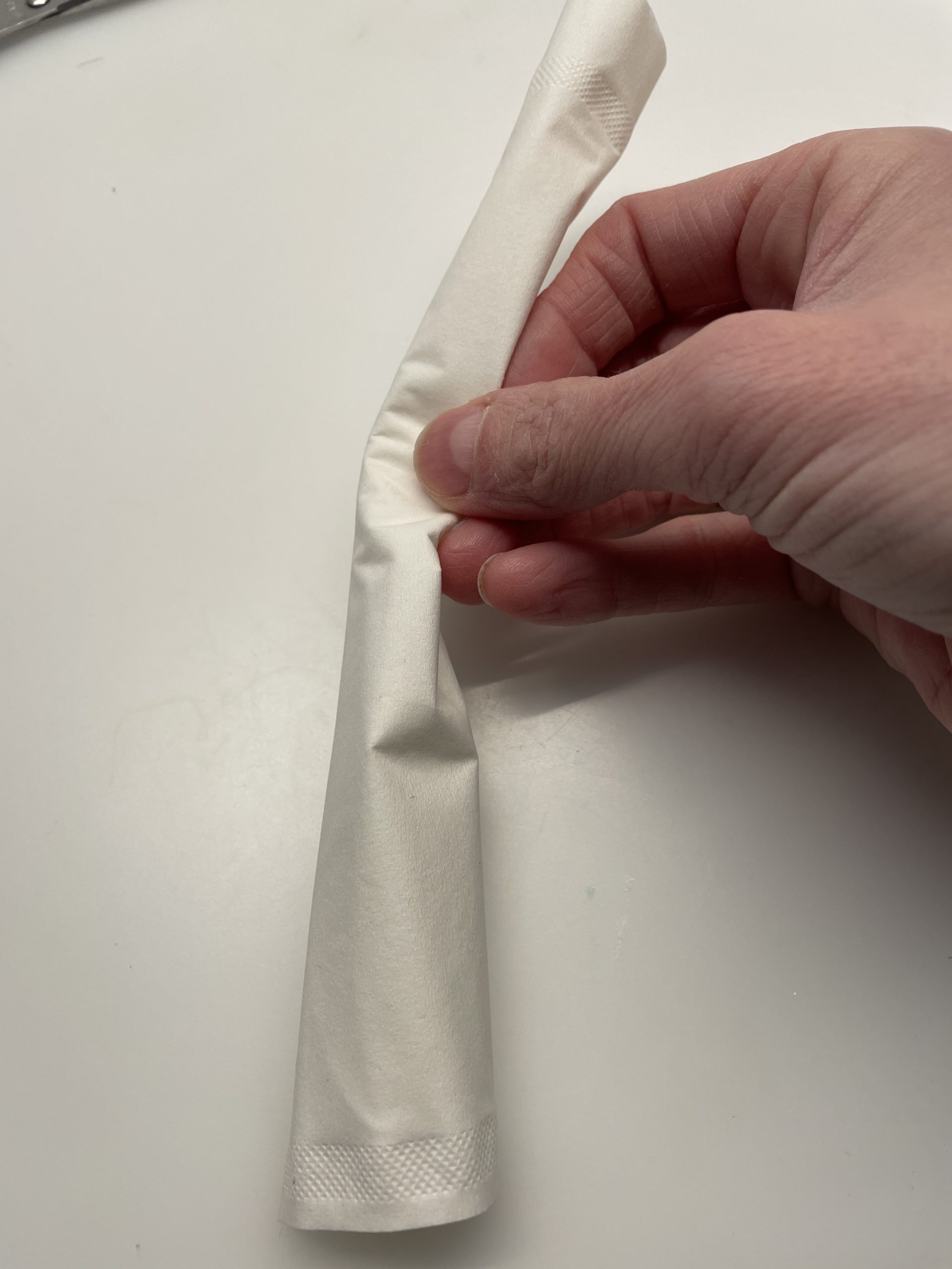 Bild zum Schritt 13 für die Kinder-Beschäftigung: 'Rollt das Taschentuch von der langen Seite ausgehend zusammen.'