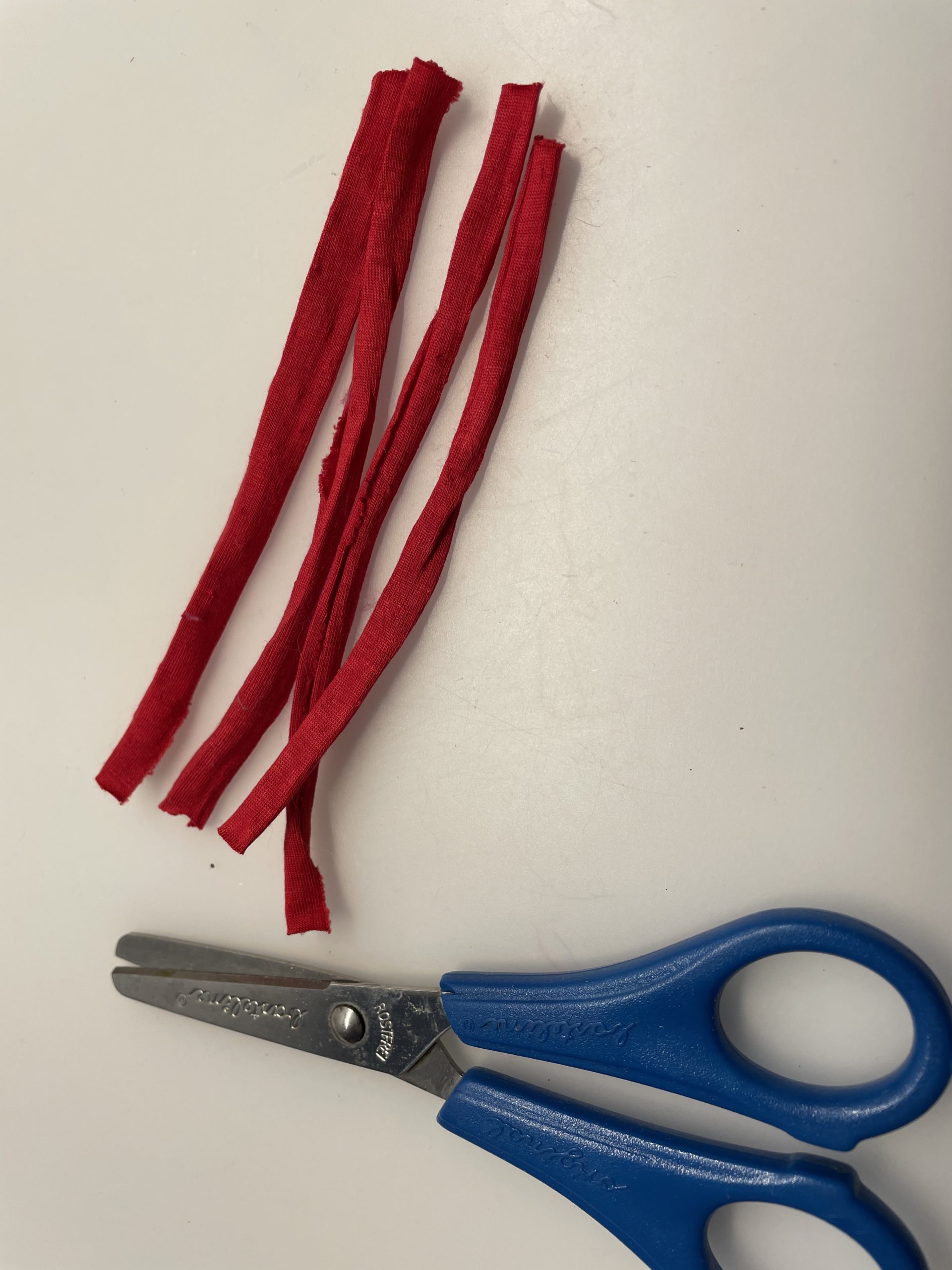 Bild zum Schritt 6 für das Bastel- und DIY-Abenteuer für Kinder: 'Schneidet euch 3-4 Streifen Jerseyband auf eine Länge von 10cm...'