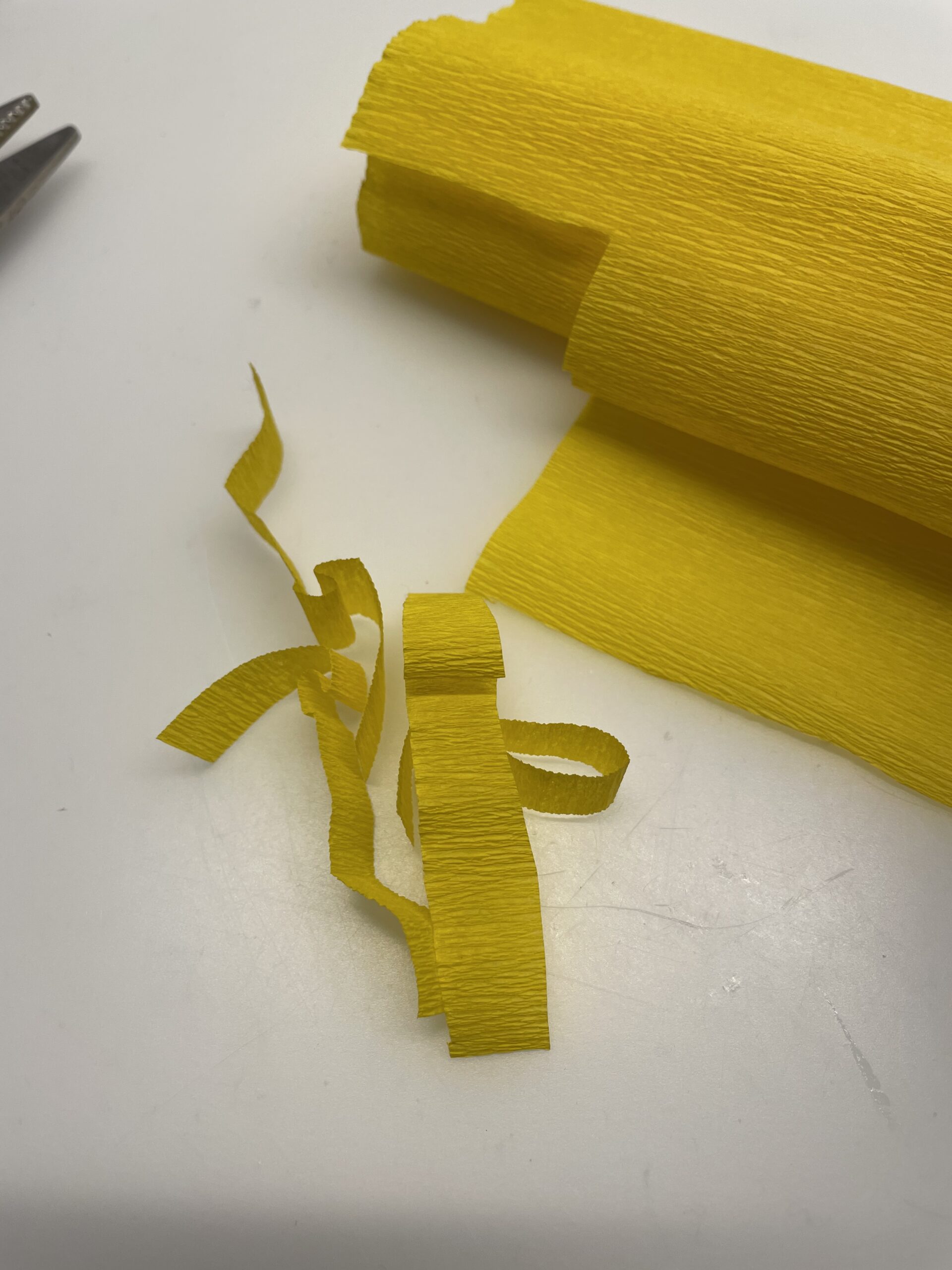 Bild zum Schritt 3 für das Bastel- und DIY-Abenteuer für Kinder: 'Dann legt ihr ein paar gelbe Schnipsel Krepppapier in eines...'