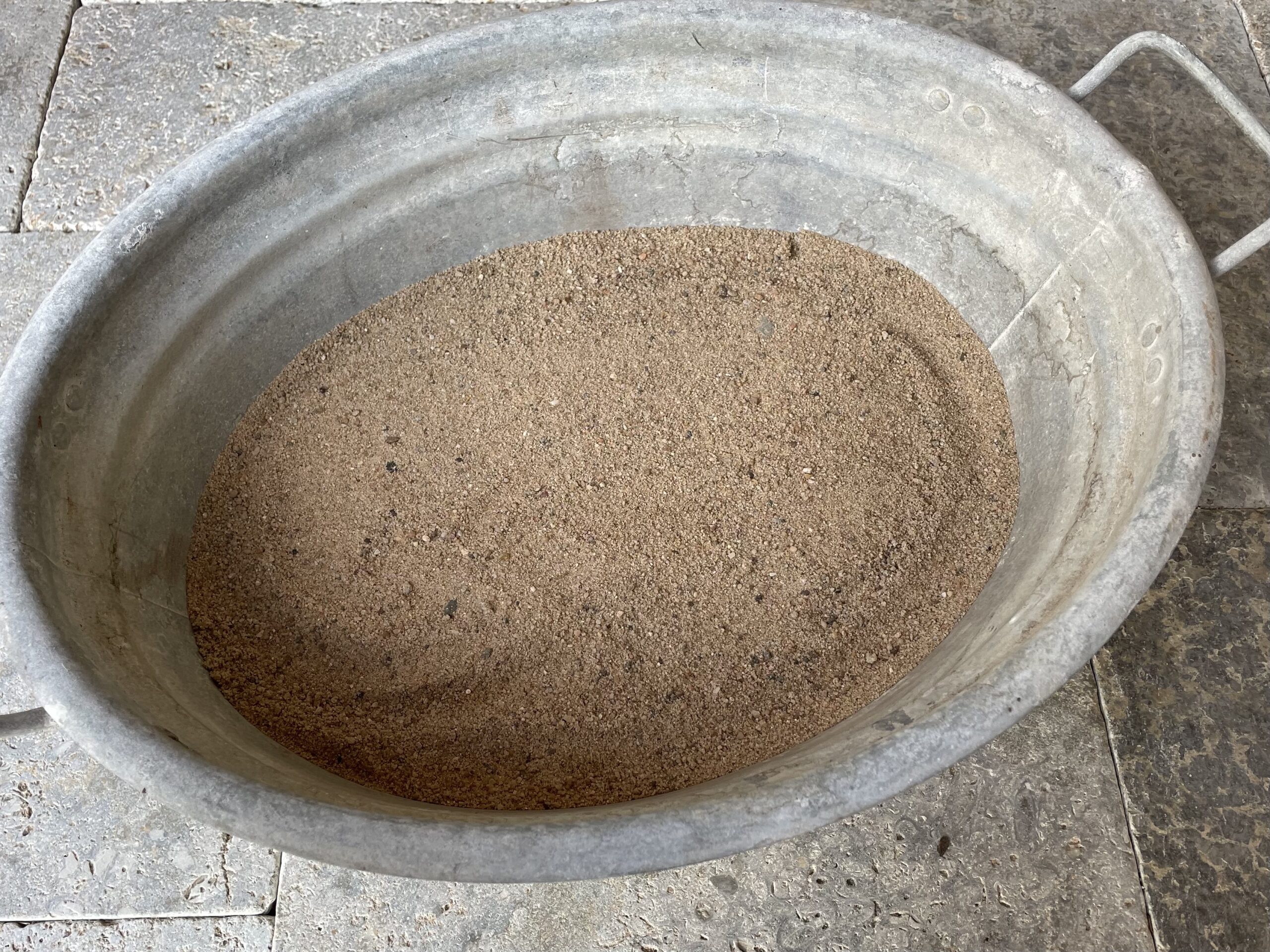 Bild zum Schritt 1 für das Bastel- und DIY-Abenteuer für Kinder: 'Füllt zuerst in eine Blechwanne Sand oder Wasser.'