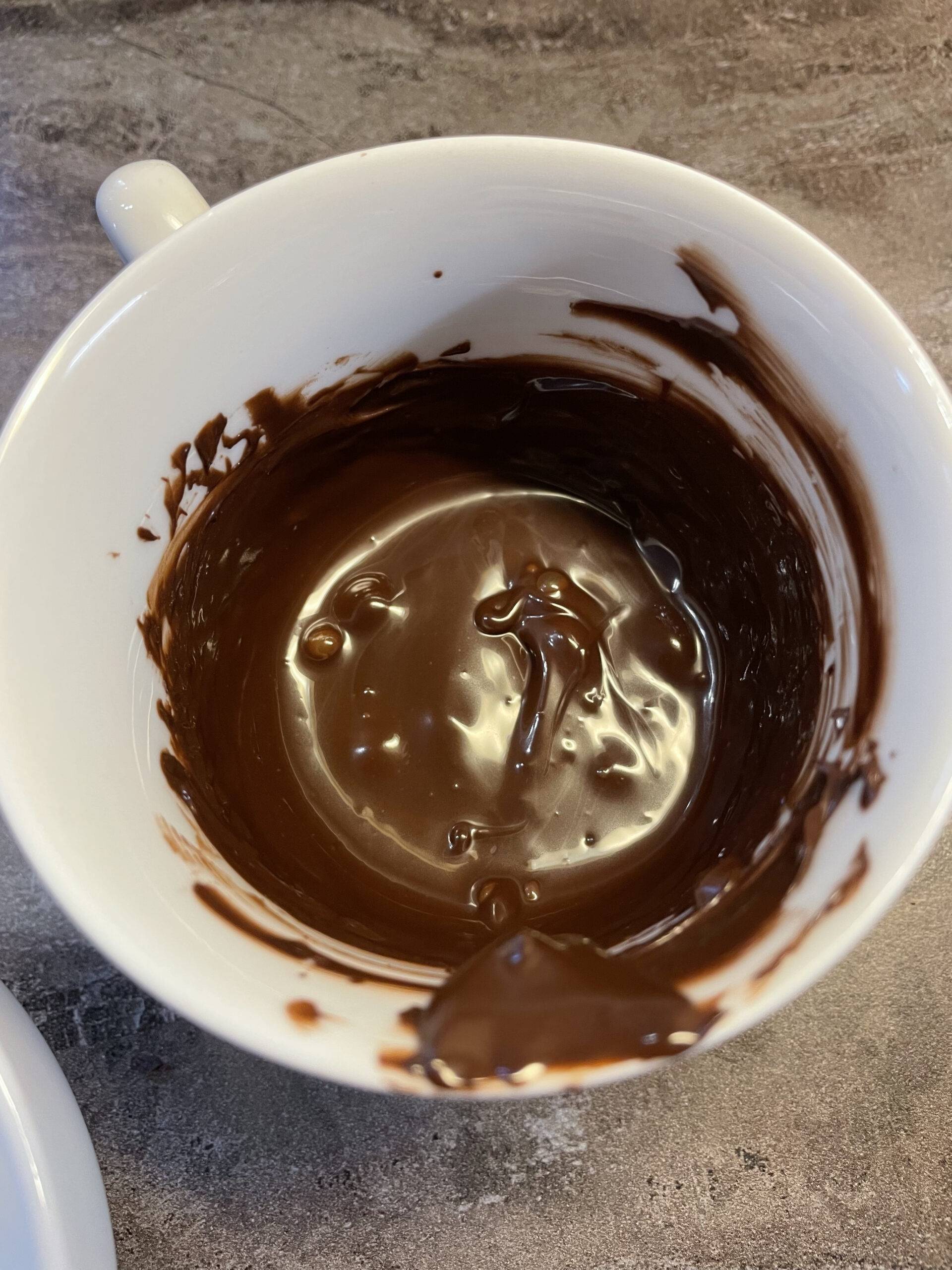 Bild zum Schritt 14 für das Bastel- und DIY-Abenteuer für Kinder: 'Schmelzt nun zwei Esslöffel Schokoladenglasur in eine Tasse im Wasserbad....'