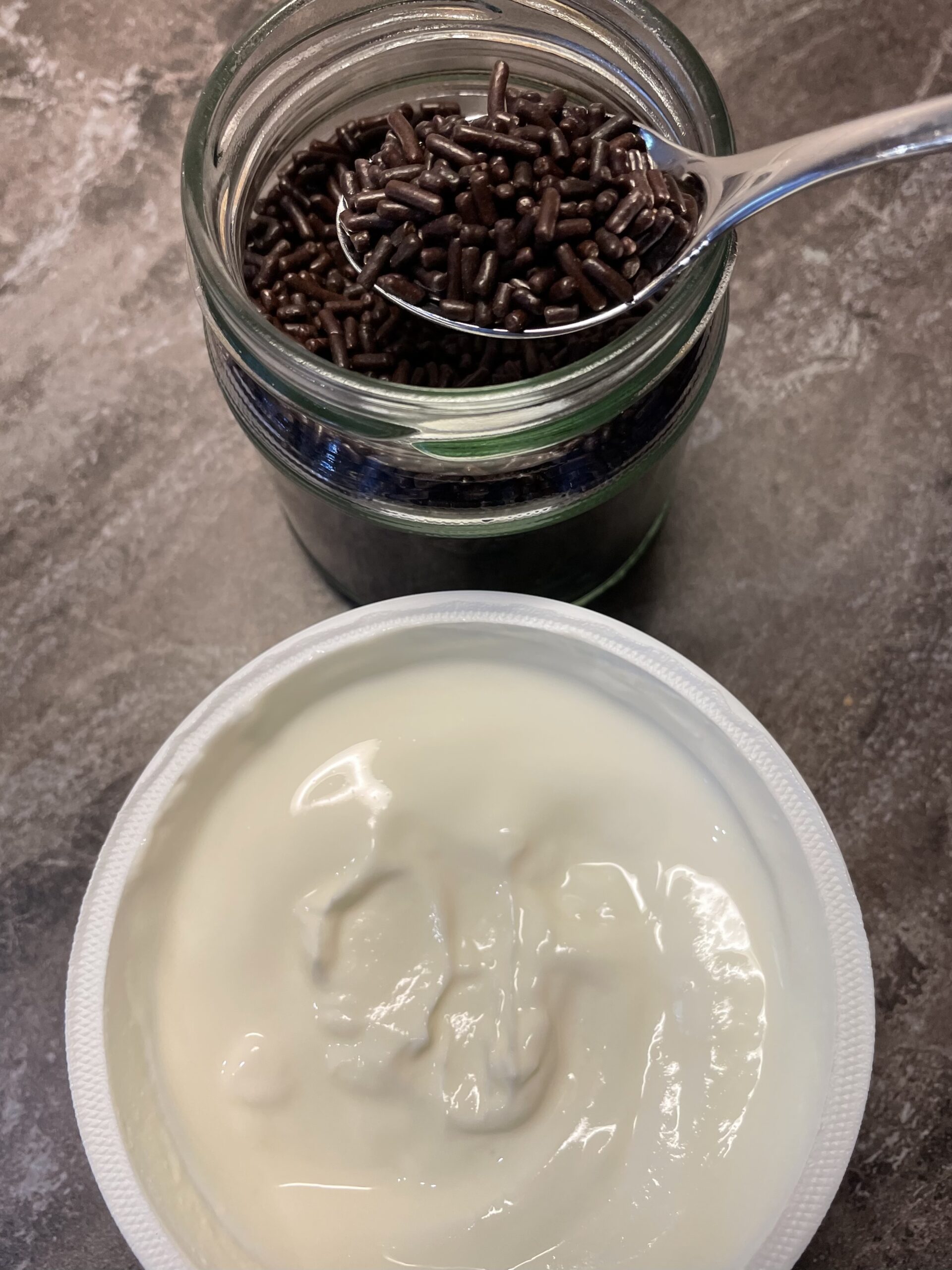 Bild zum Schritt 13 für das Bastel- und DIY-Abenteuer für Kinder: 'Anschließend verfeinert ihr den Joghurt mit 3 Teelöffel Schokoladenstreusel. ...'
