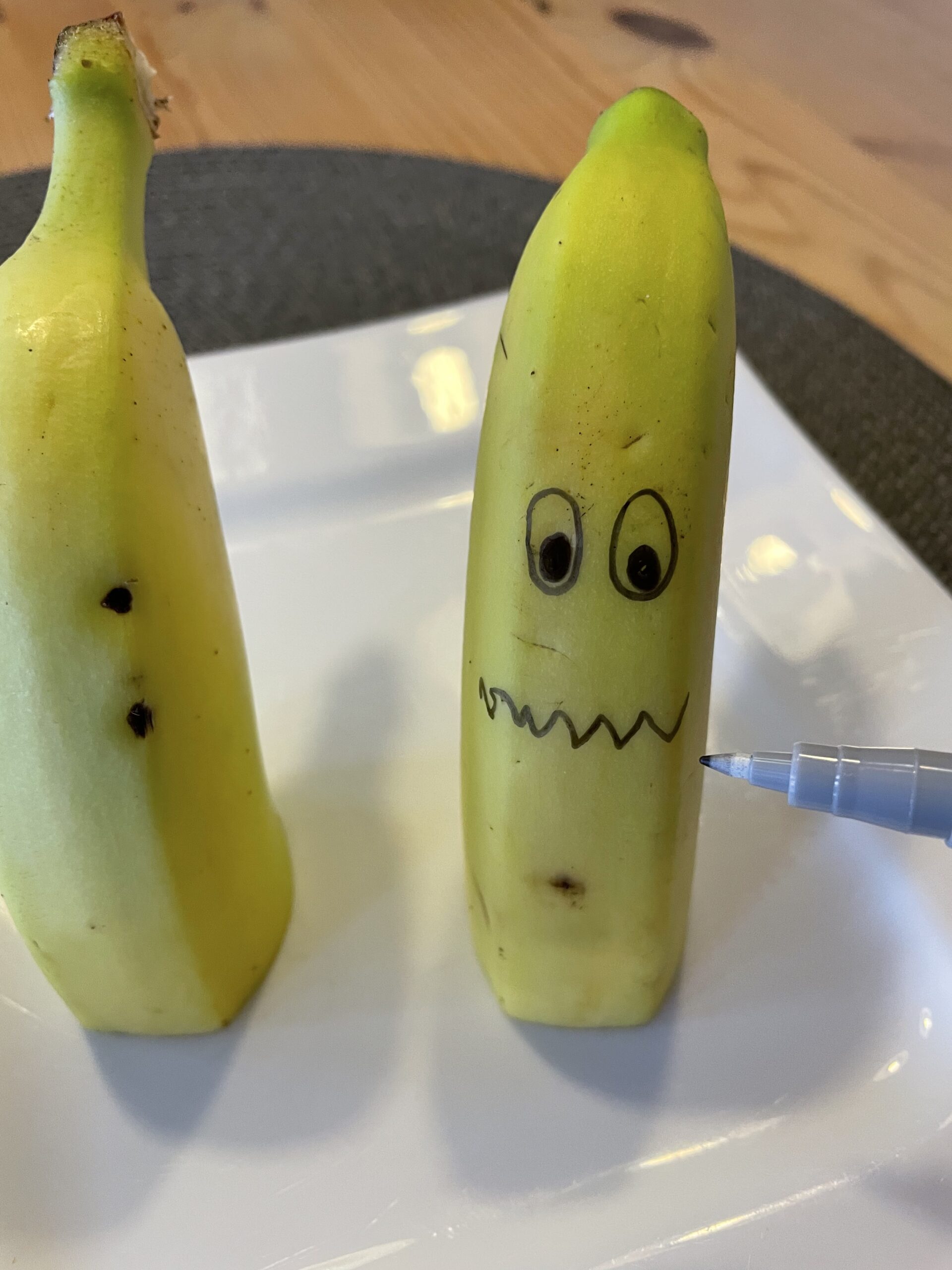 Bild zum Schritt 18 für das Bastel- und DIY-Abenteuer für Kinder: 'Anschließend malt ihr auf jede Bananenhälfte ein Gesicht.'