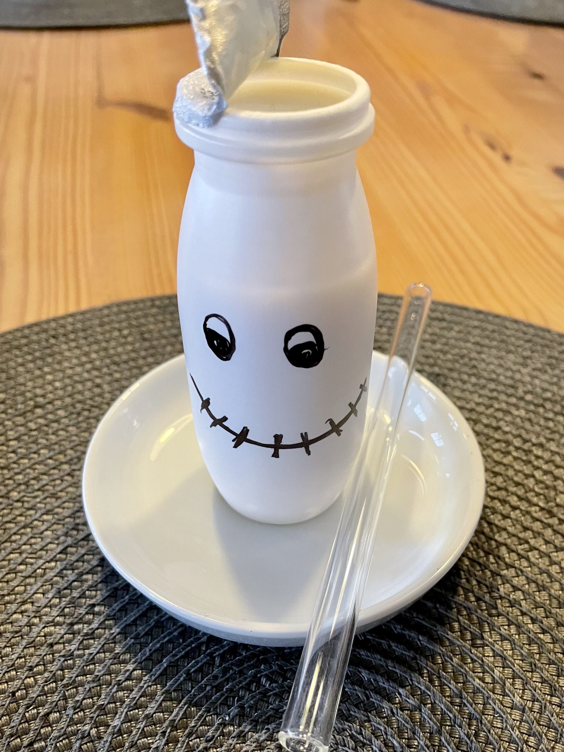 Bild zum Schritt 5 für das Bastel- und DIY-Abenteuer für Kinder: 'Stellt den Trinkjoghurt anschließend auf einen kleinen Teller und legt...'