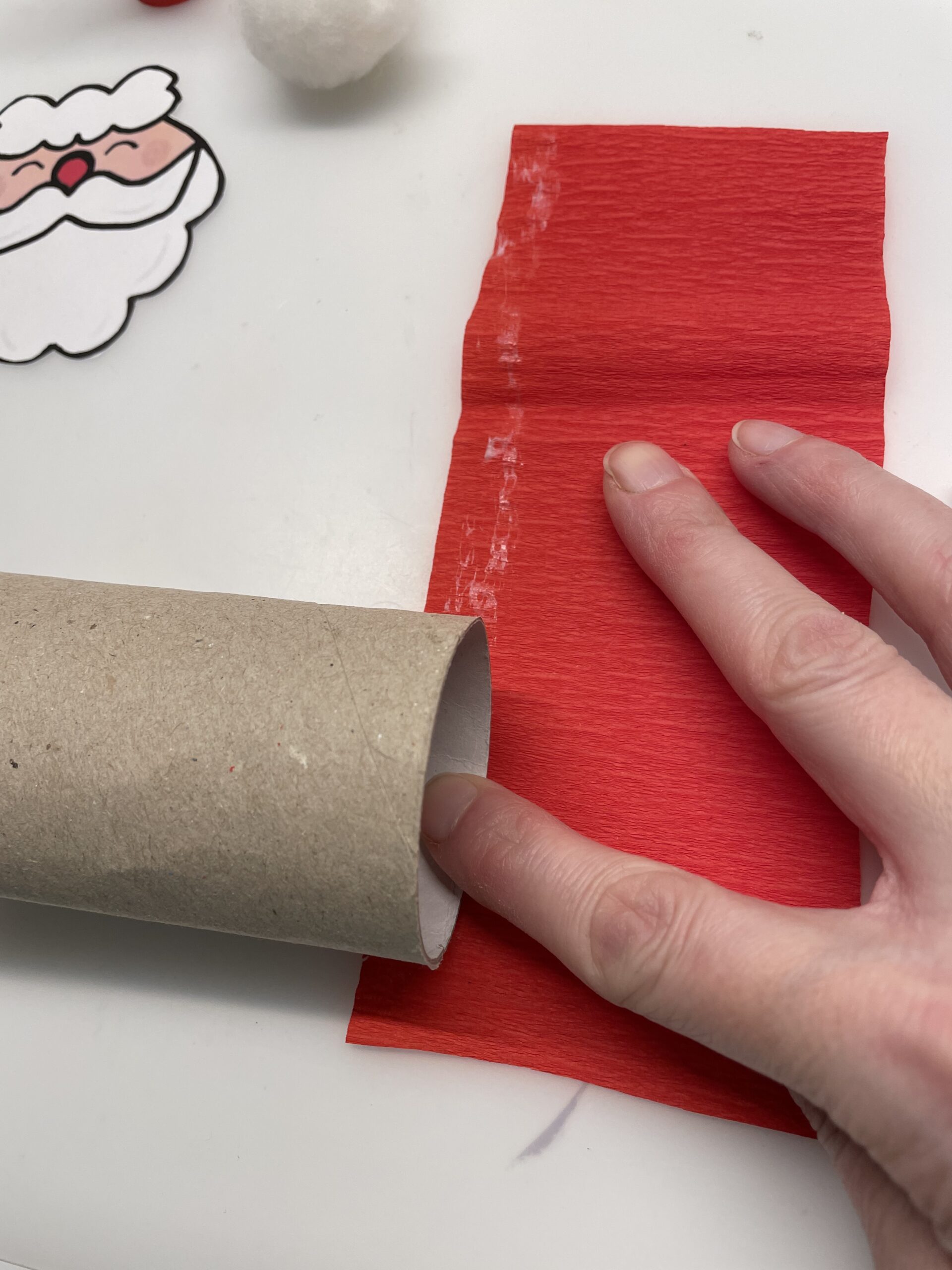 Bild zum Schritt 5 für das Bastel- und DIY-Abenteuer für Kinder: 'Nun legt ihr die Papprolle auf das Krepppapier und klebt...'