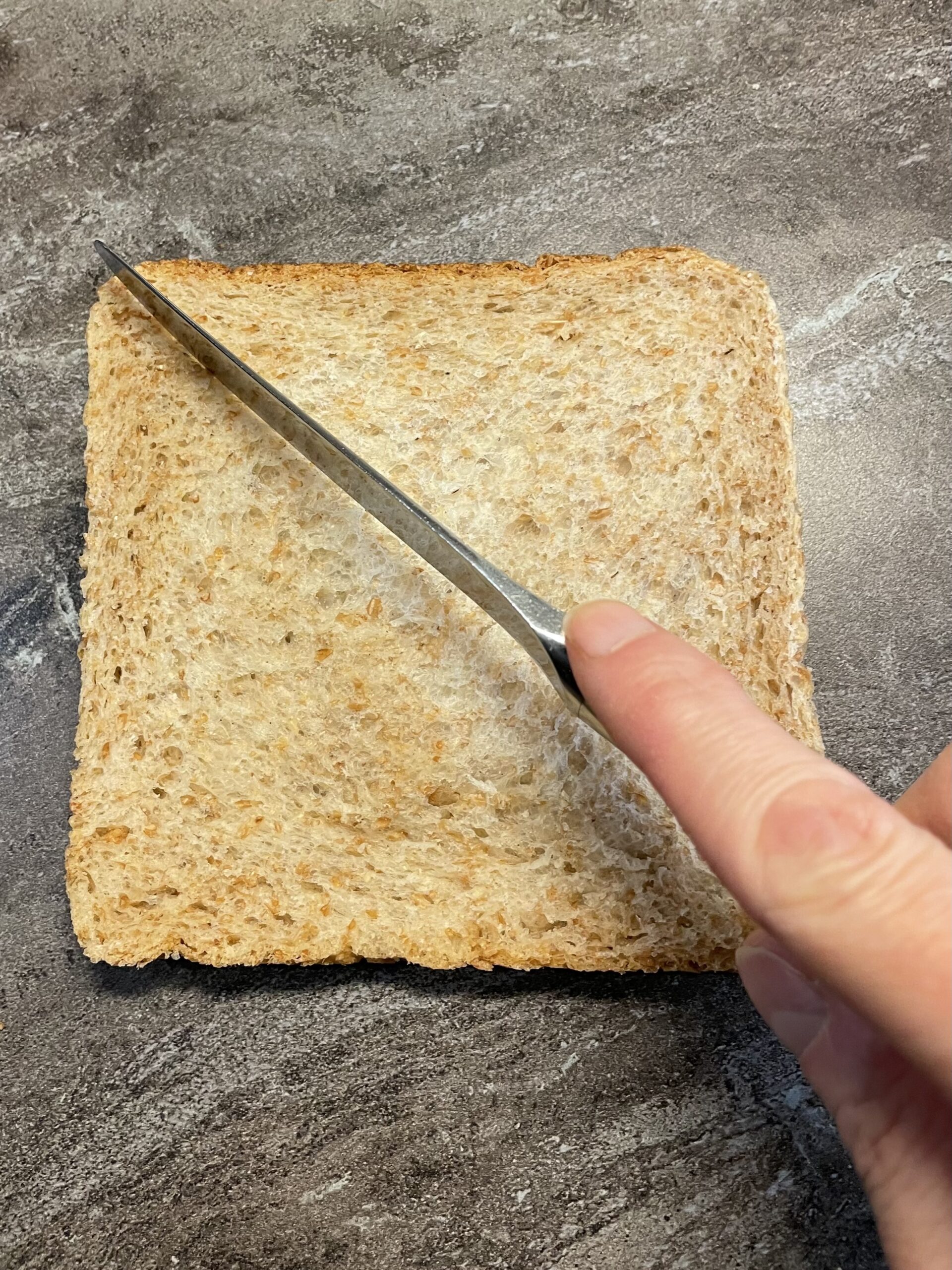 Bild zum Schritt 17 für das Bastel- und DIY-Abenteuer für Kinder: 'Schneidet hierfür die Scheibe Toast zuerst diagonal in zwei Hälften...'