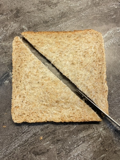 Bild zum Schritt 14 für das Bastel- und DIY-Abenteuer für Kinder: 'Schneidet zuerst die Scheibe Toast diagonal in zwei Hälften (Dreiecke)....'