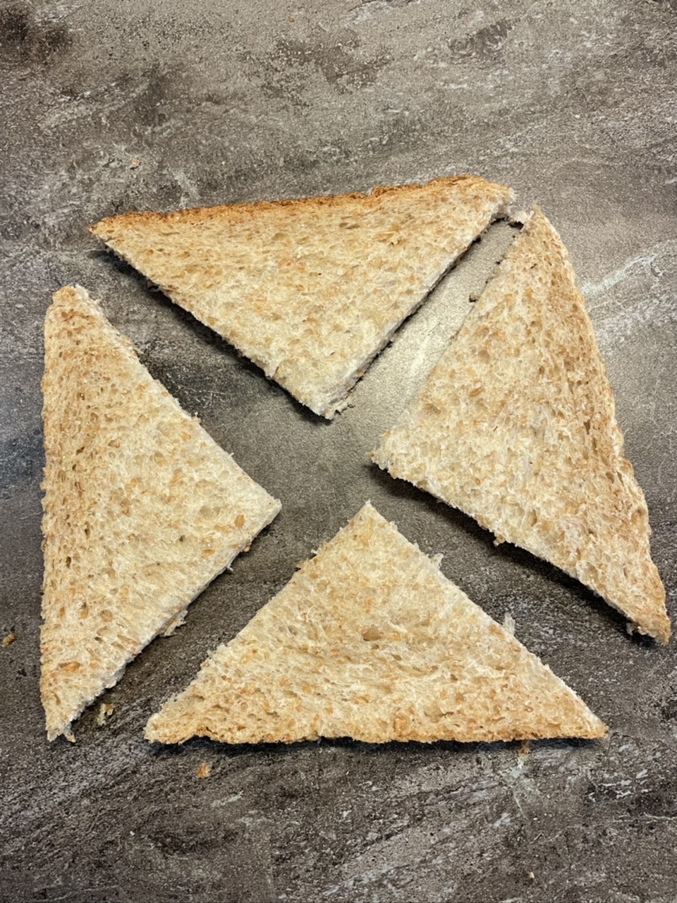 Bild zum Schritt 19 für das Bastel- und DIY-Abenteuer für Kinder: 'So entstehen insgesamt vier Dreiecke aus einer Scheibe Toast.'