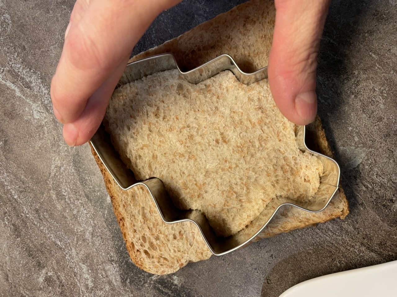 Bild zum Schritt 4 für das Bastel- und DIY-Abenteuer für Kinder: 'Danach drückt ihr die Ausstechform fest in den Toast hinein.'
