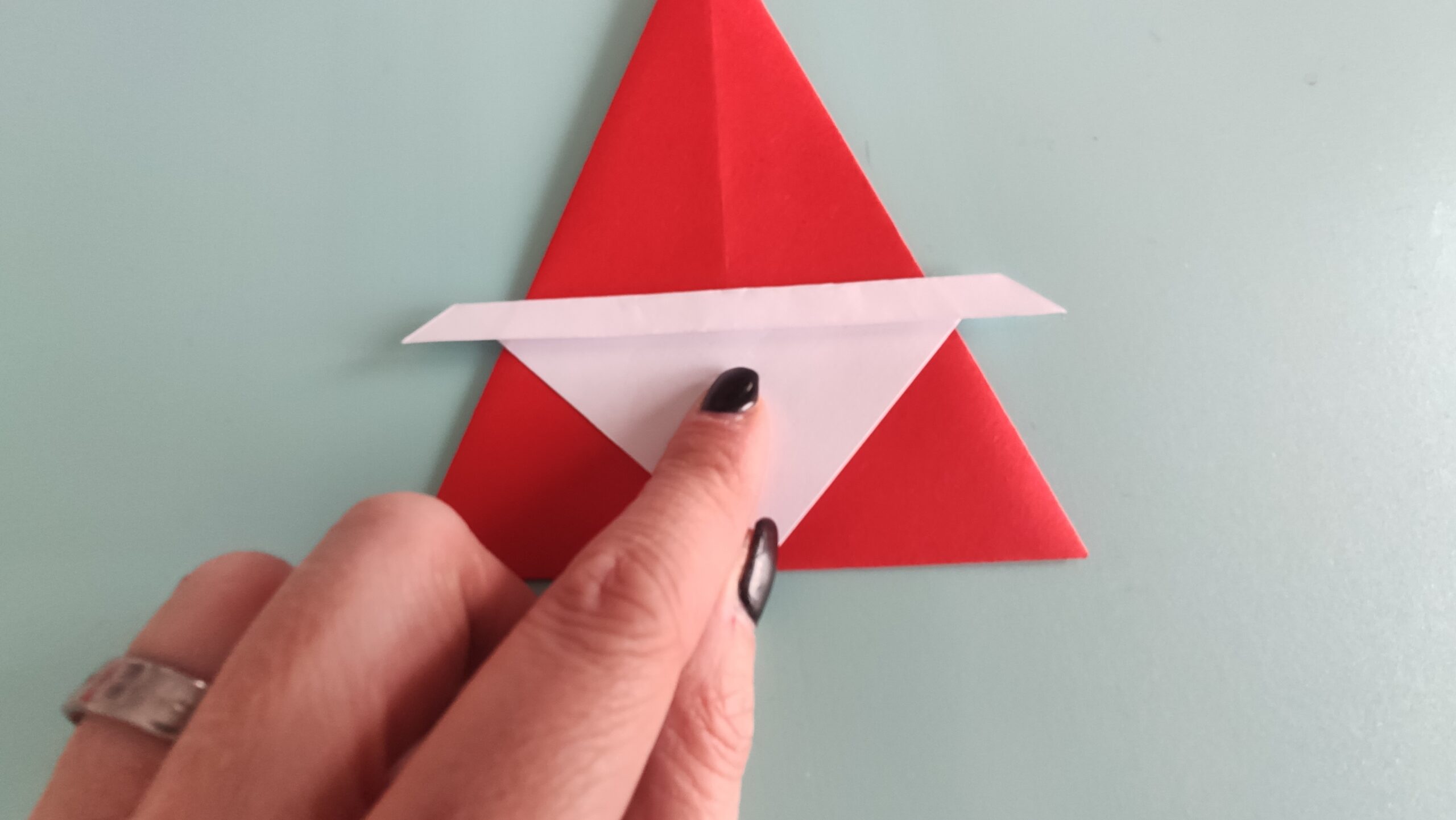 Bild zum Schritt 9 für das Bastel- und DIY-Abenteuer für Kinder: 'Jetzt legt ihr das weiße Dreieck auf das rote Dreieck....'