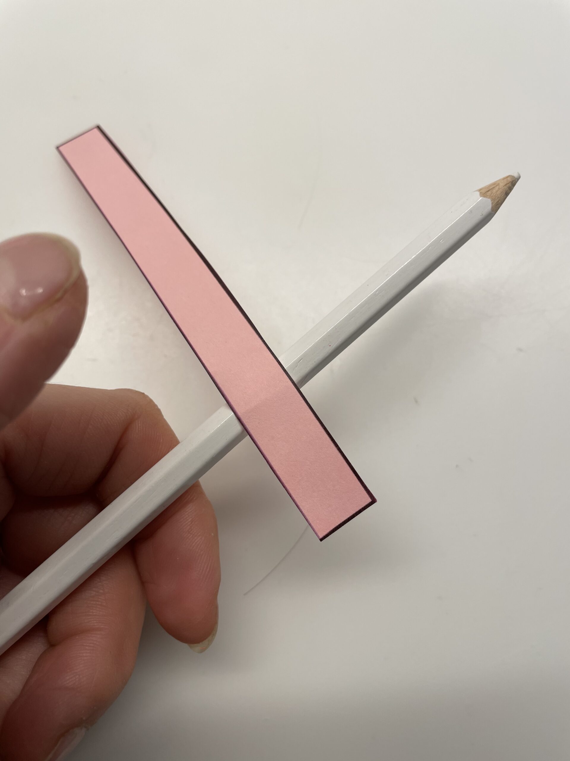 Bild zum Schritt 17 für das Bastel- und DIY-Abenteuer für Kinder: 'Schneidet für den Ringelschwanz einen rosafarbenen Papierstreifen mit den Maßen:...'