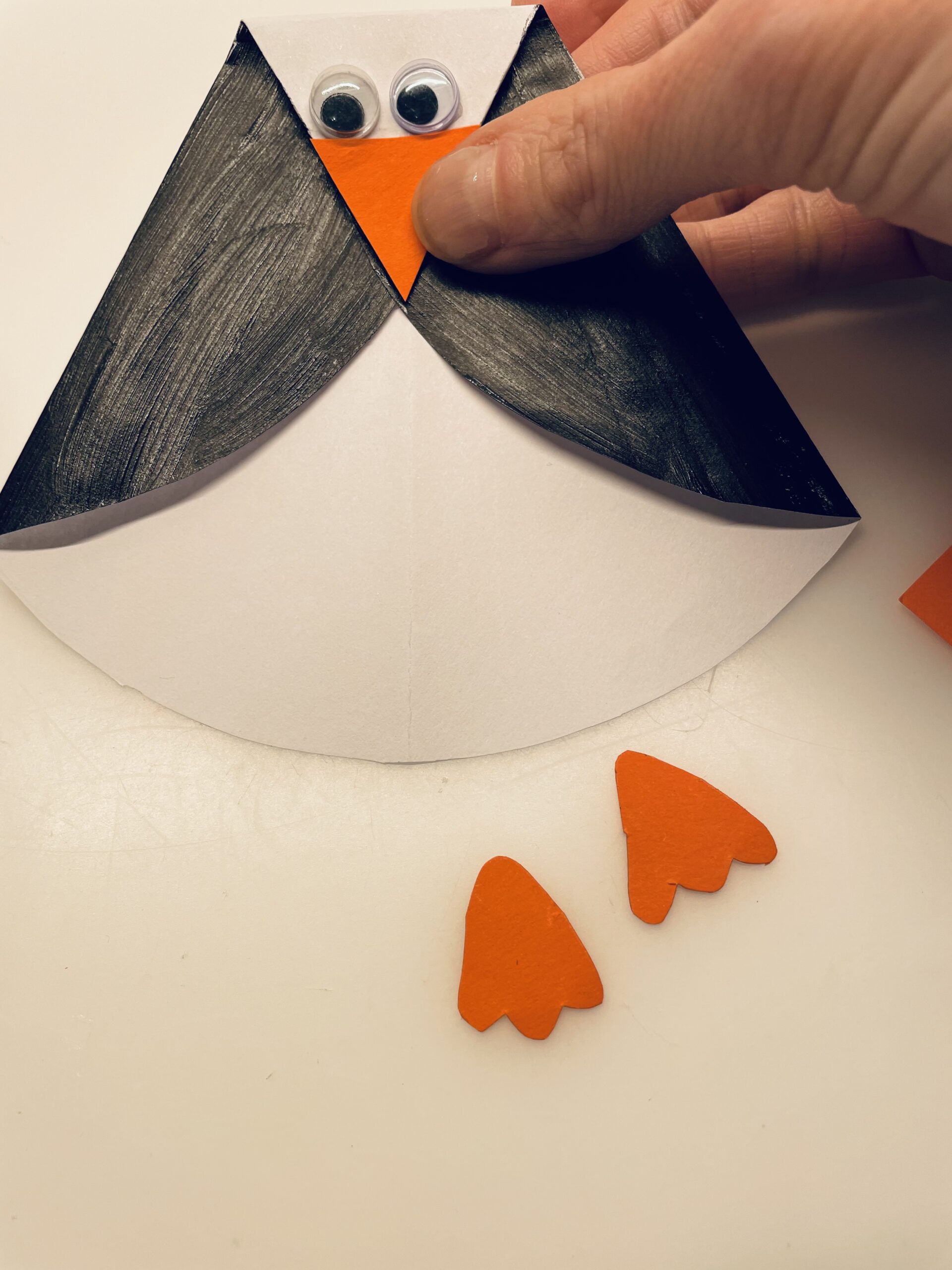 Bild zum Schritt 9 für das Bastel- und DIY-Abenteuer für Kinder: 'Jetzt malt euch auf orangefarbenes Papier zwei Füße für den...'