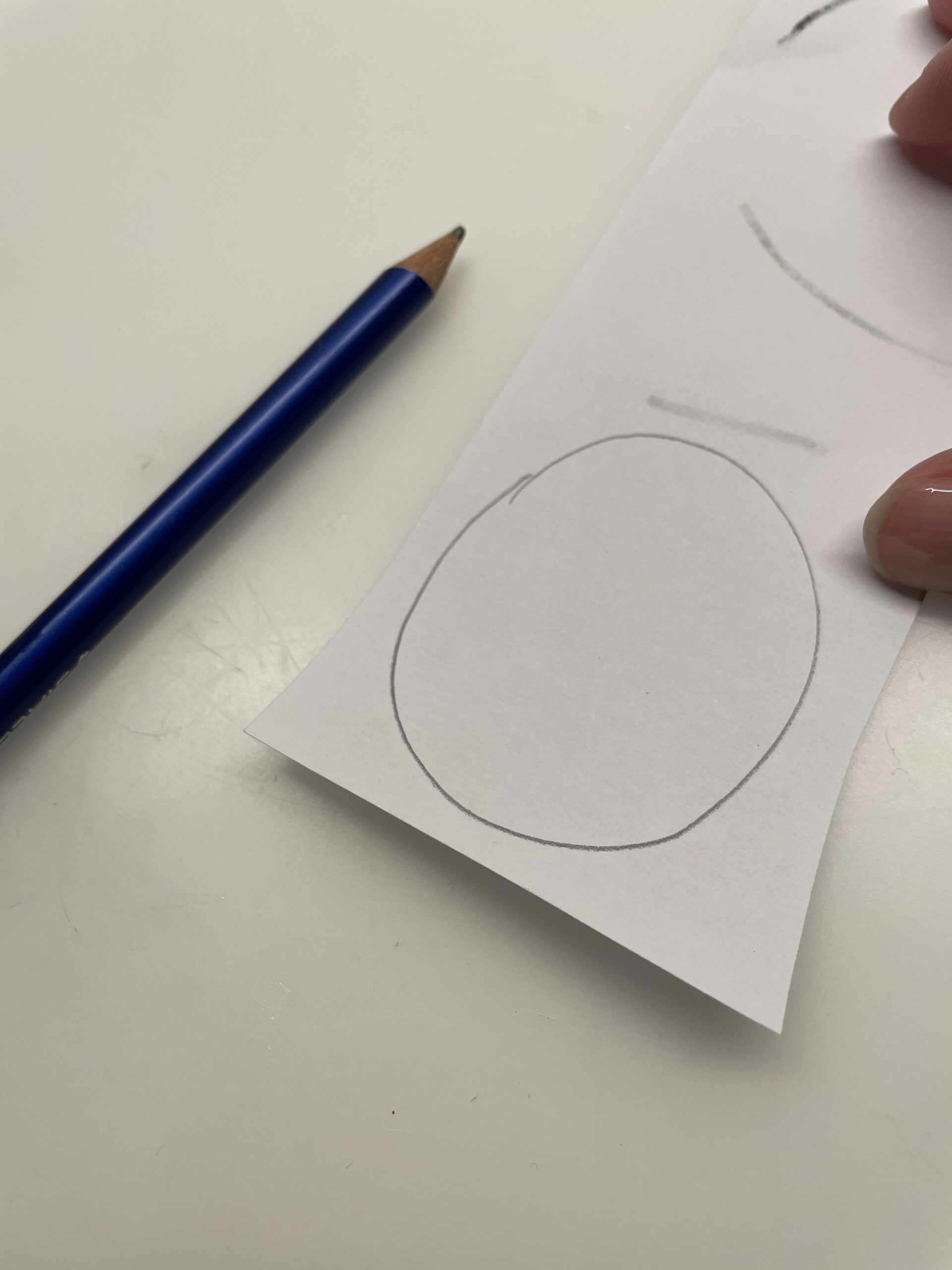 Bild zum Schritt 4 für das Bastel- und DIY-Abenteuer für Kinder: 'Jetzt malt ihr auf ein weißes Papier einen ovalen Kreis...'
