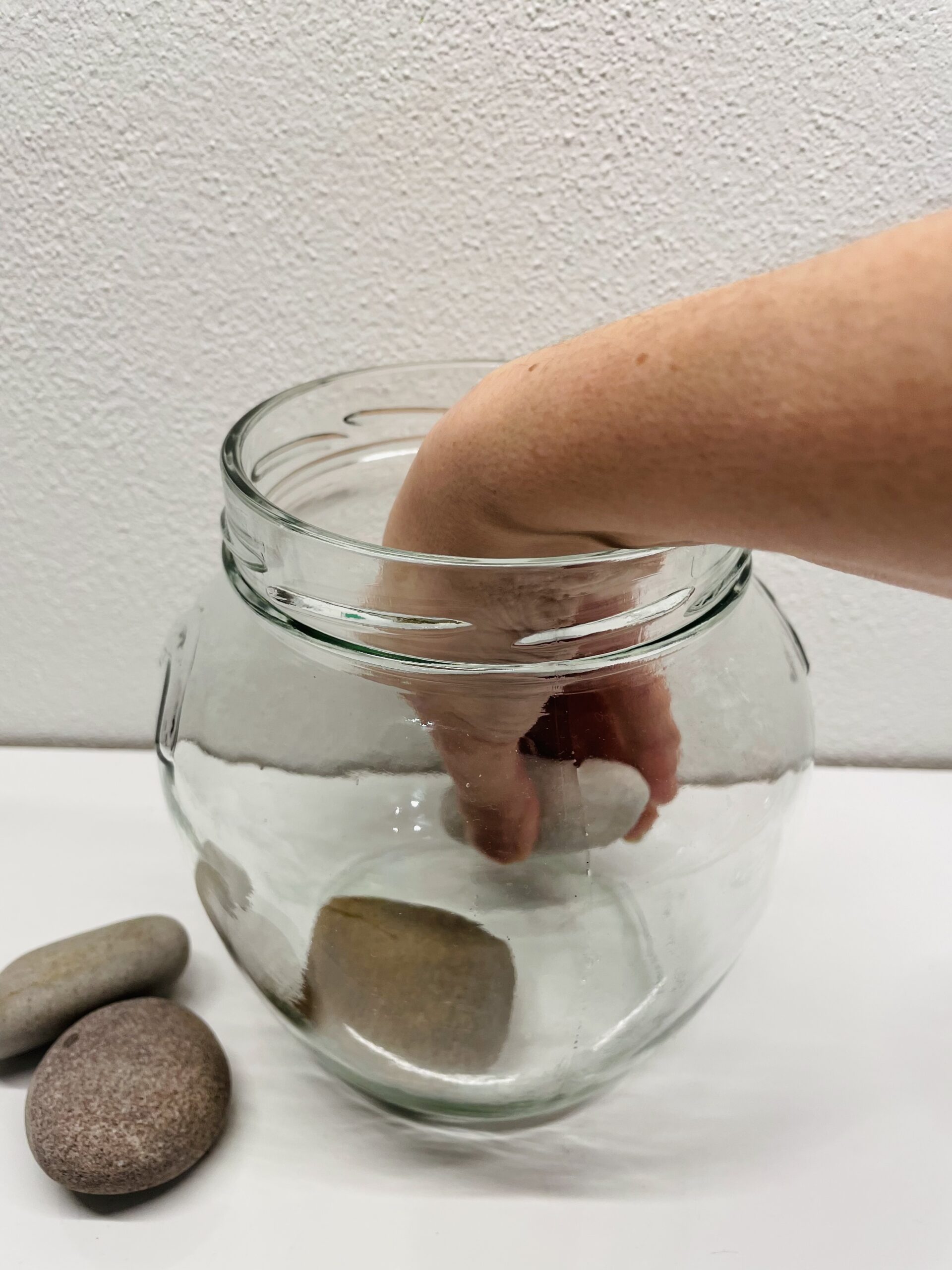 Bild zum Schritt 2 für das Bastel- und DIY-Abenteuer für Kinder: 'Dann legt ihr die sauberen Steine vorsichtig in das Glas.'