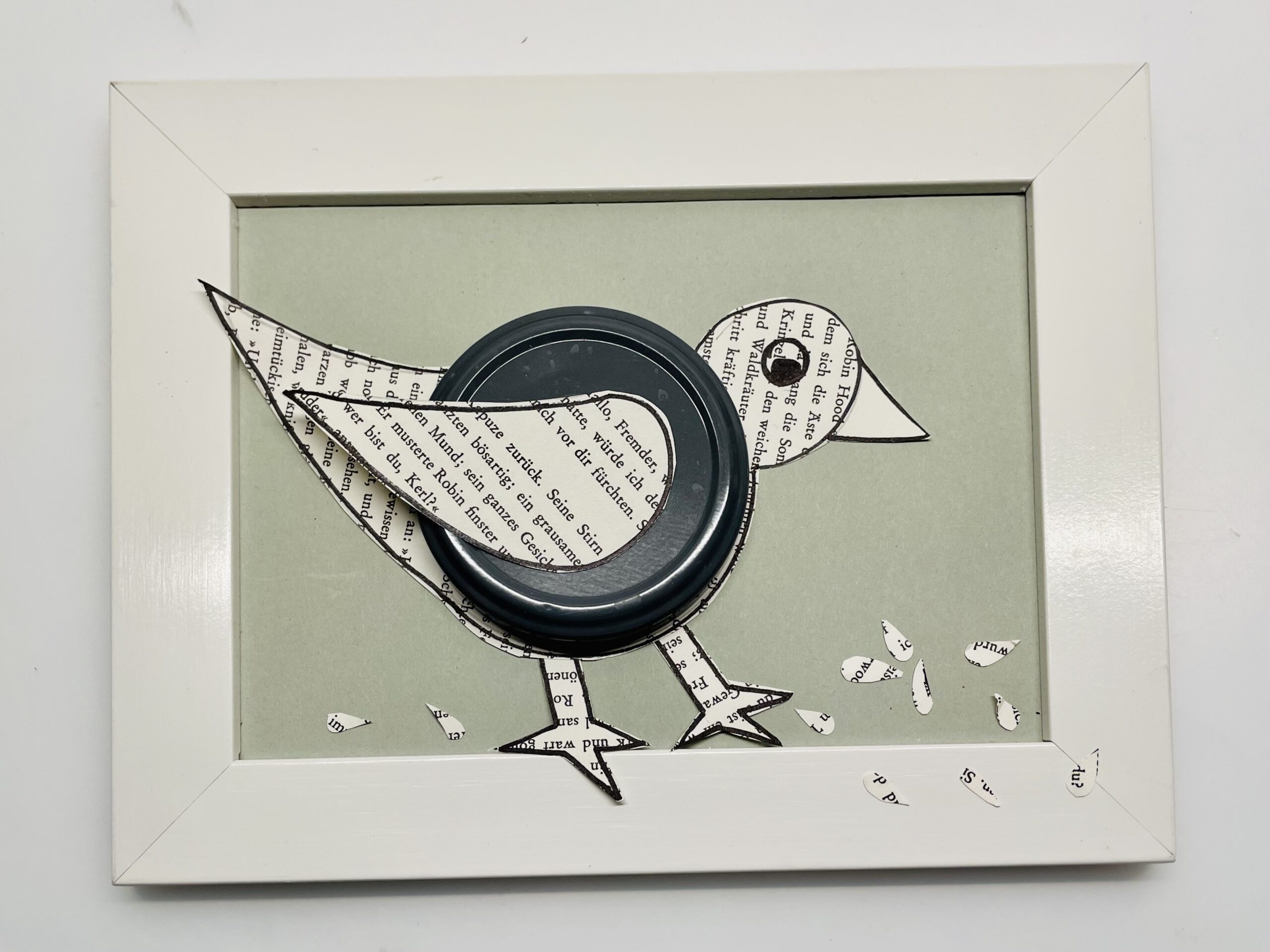 Bild zum Schritt 12 für das Bastel- und DIY-Abenteuer für Kinder: 'Klebt den Vogel auf einen Bilderrahmen. Schneidet kleine Schnipsel oder...'