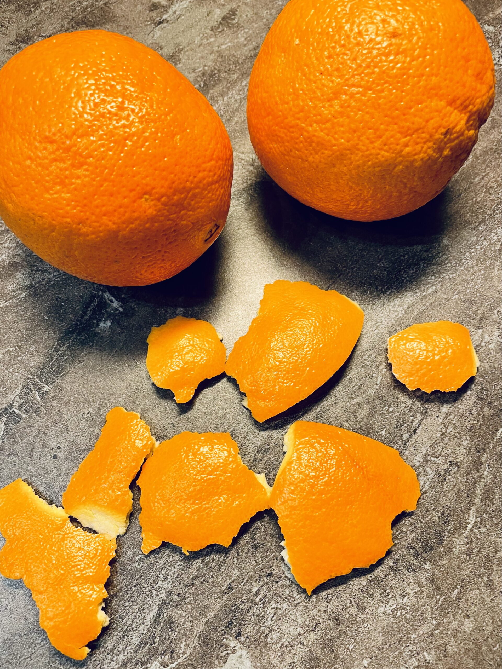 Bild zum Schritt 1 für das Bastel- und DIY-Abenteuer für Kinder: 'Schält zuerst die Orange und achtet darauf große Stücke abzuschälen.'