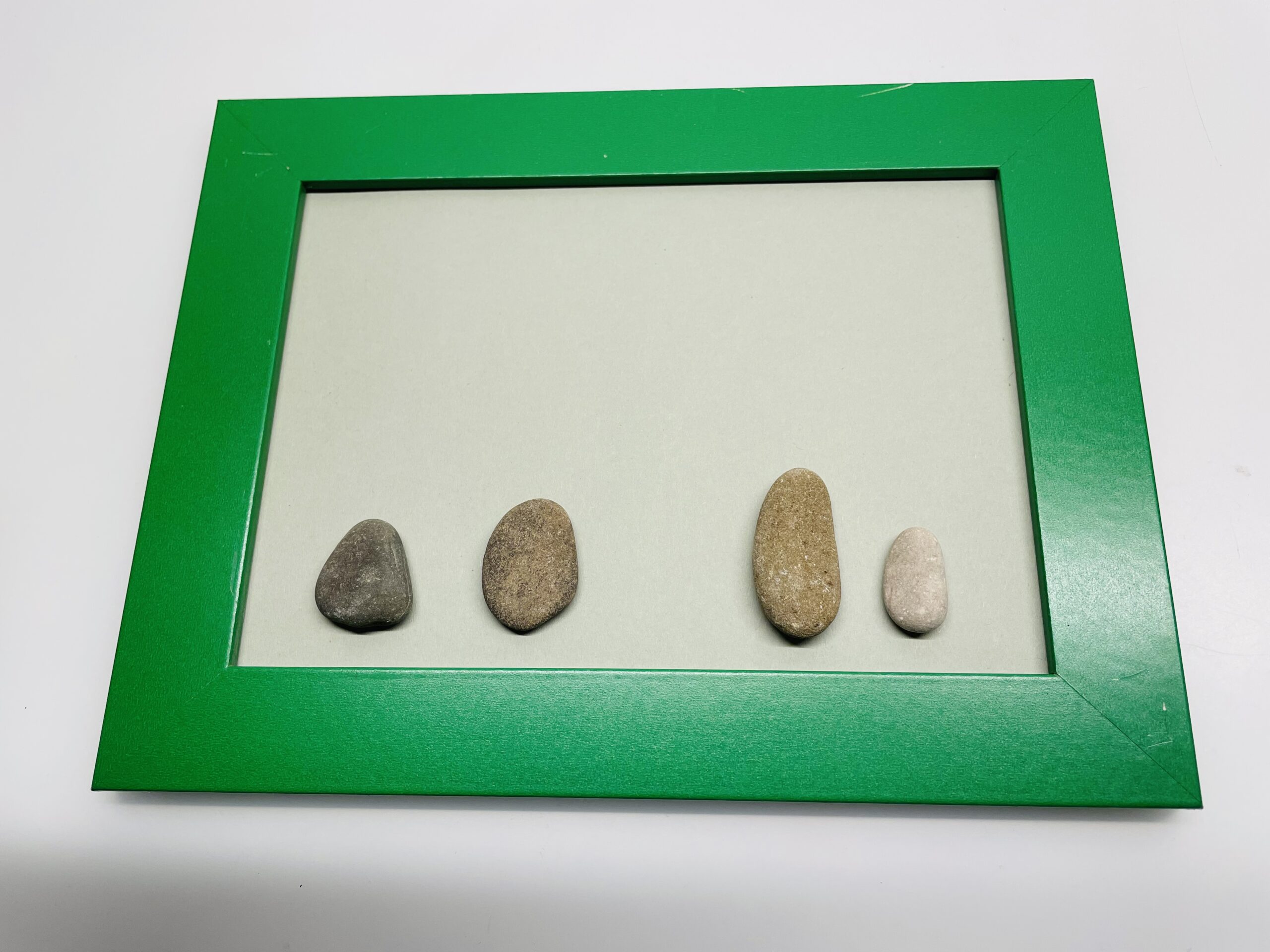 Bild zum Schritt 2 für das Bastel- und DIY-Abenteuer für Kinder: 'Anschließend legt ihr 4 längliche abgerundete Steine auf den Rahmen....'