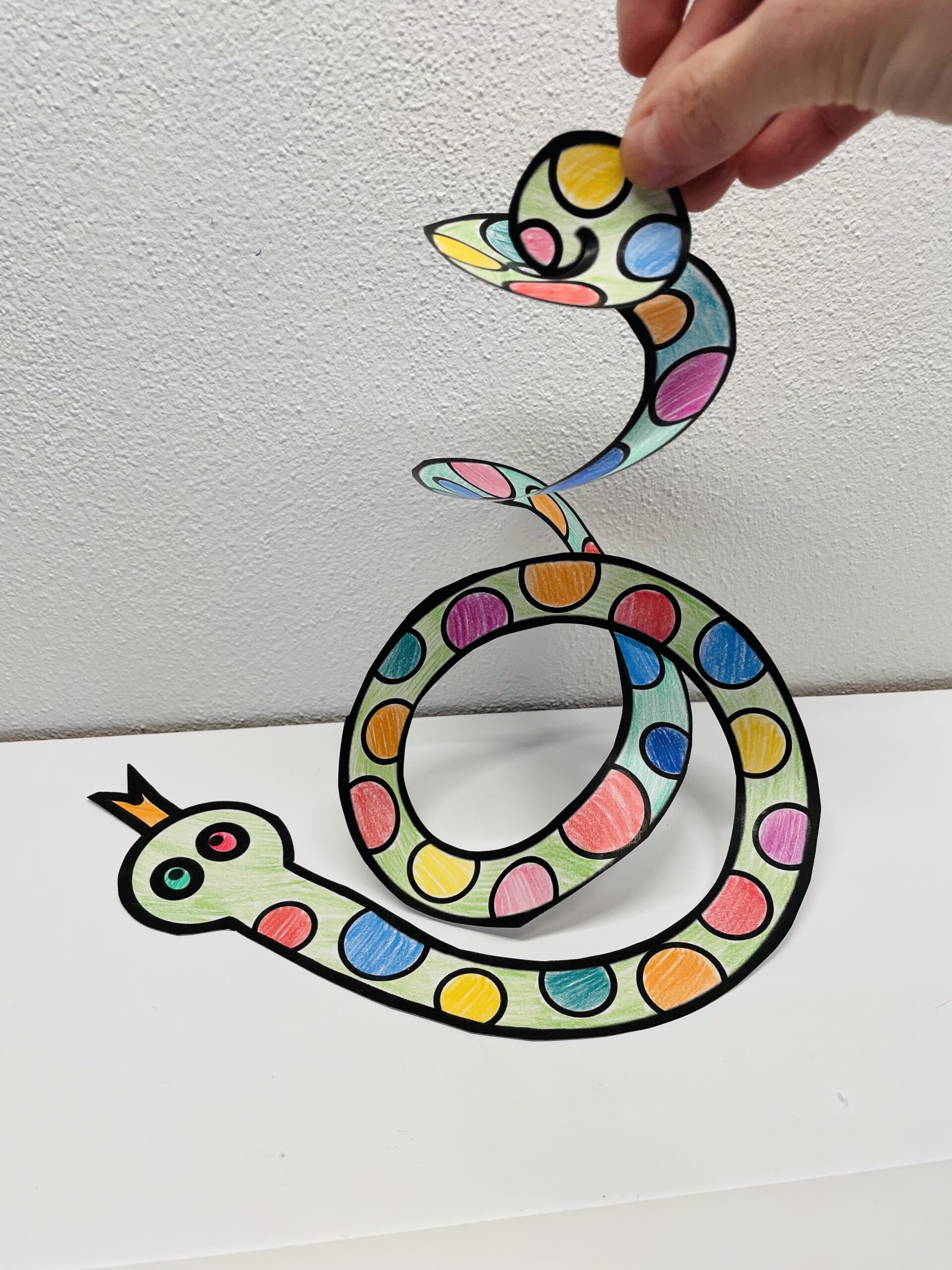 Bild zum Schritt 8 für das Bastel- und DIY-Abenteuer für Kinder: 'Hebt die Schlange vorsichtig hoch und fertig ist eure Girlande.'