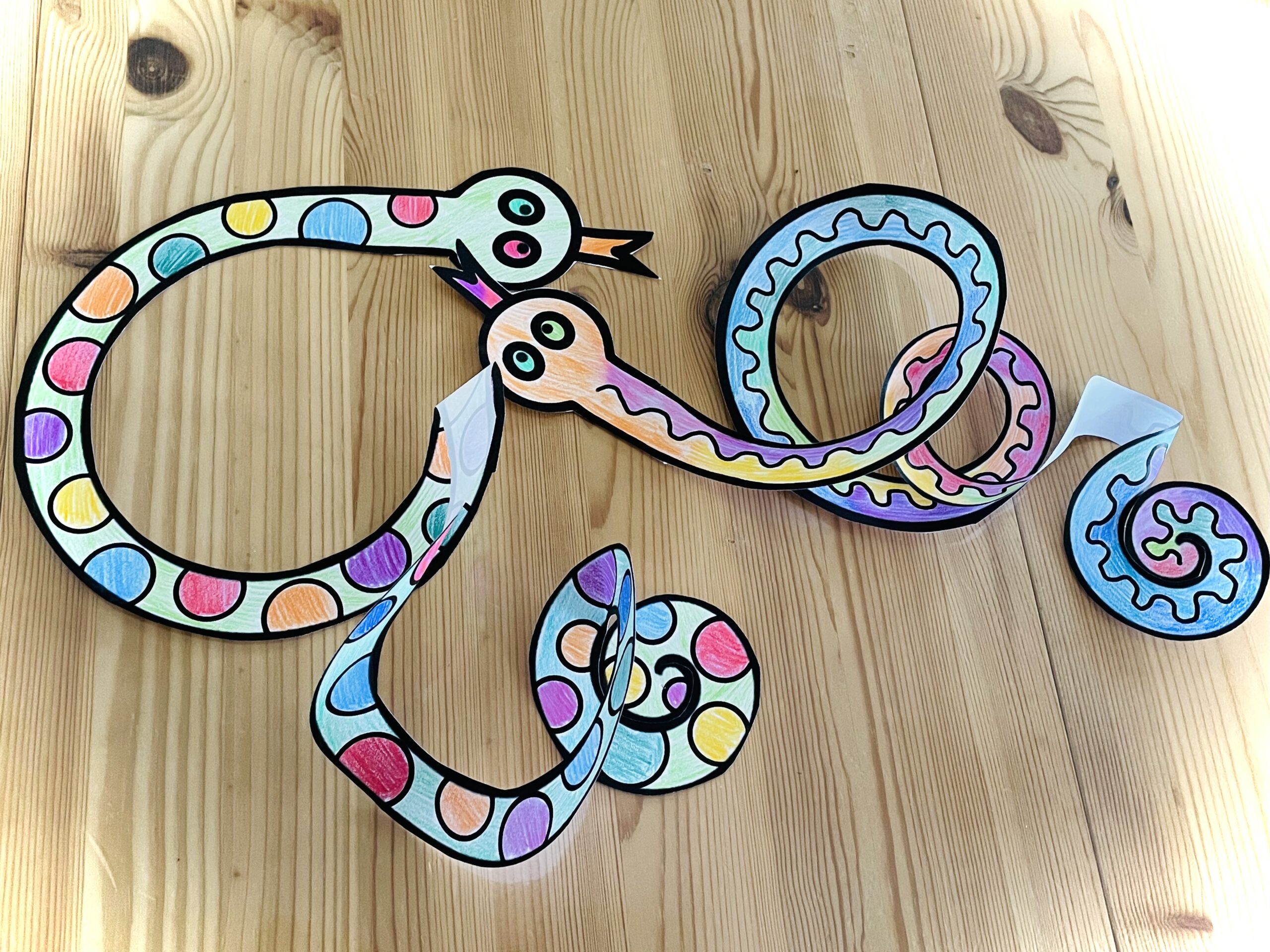 Bild zum Schritt 16 für das Bastel- und DIY-Abenteuer für Kinder: 'Dekoriert die bunten Faschings-Schlangen am Esstisch.'