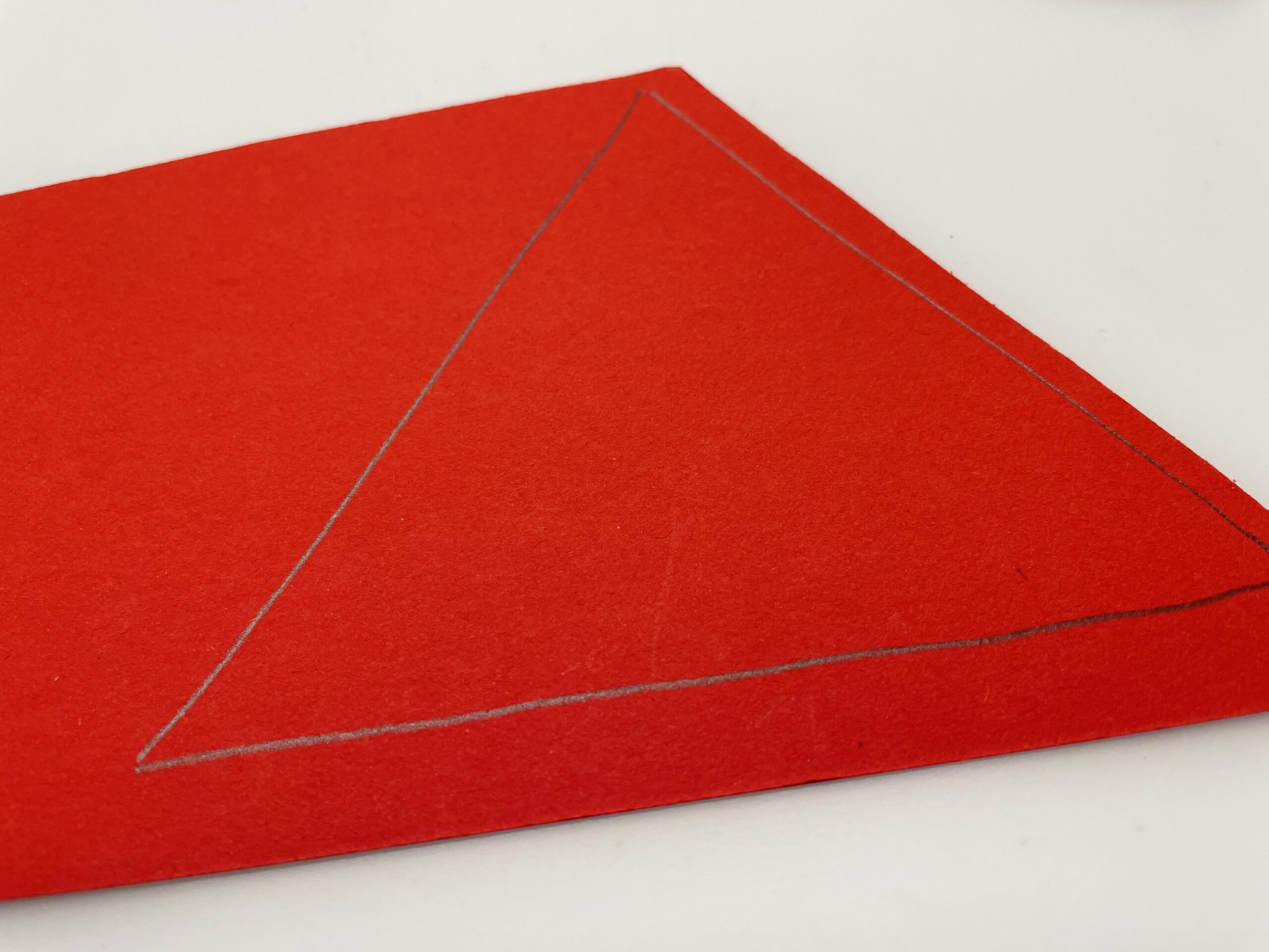 Bild zum Schritt 6 für das Bastel- und DIY-Abenteuer für Kinder: 'Dafür malt ihr ein Dreieck auf rotes, braunes oder graues...'