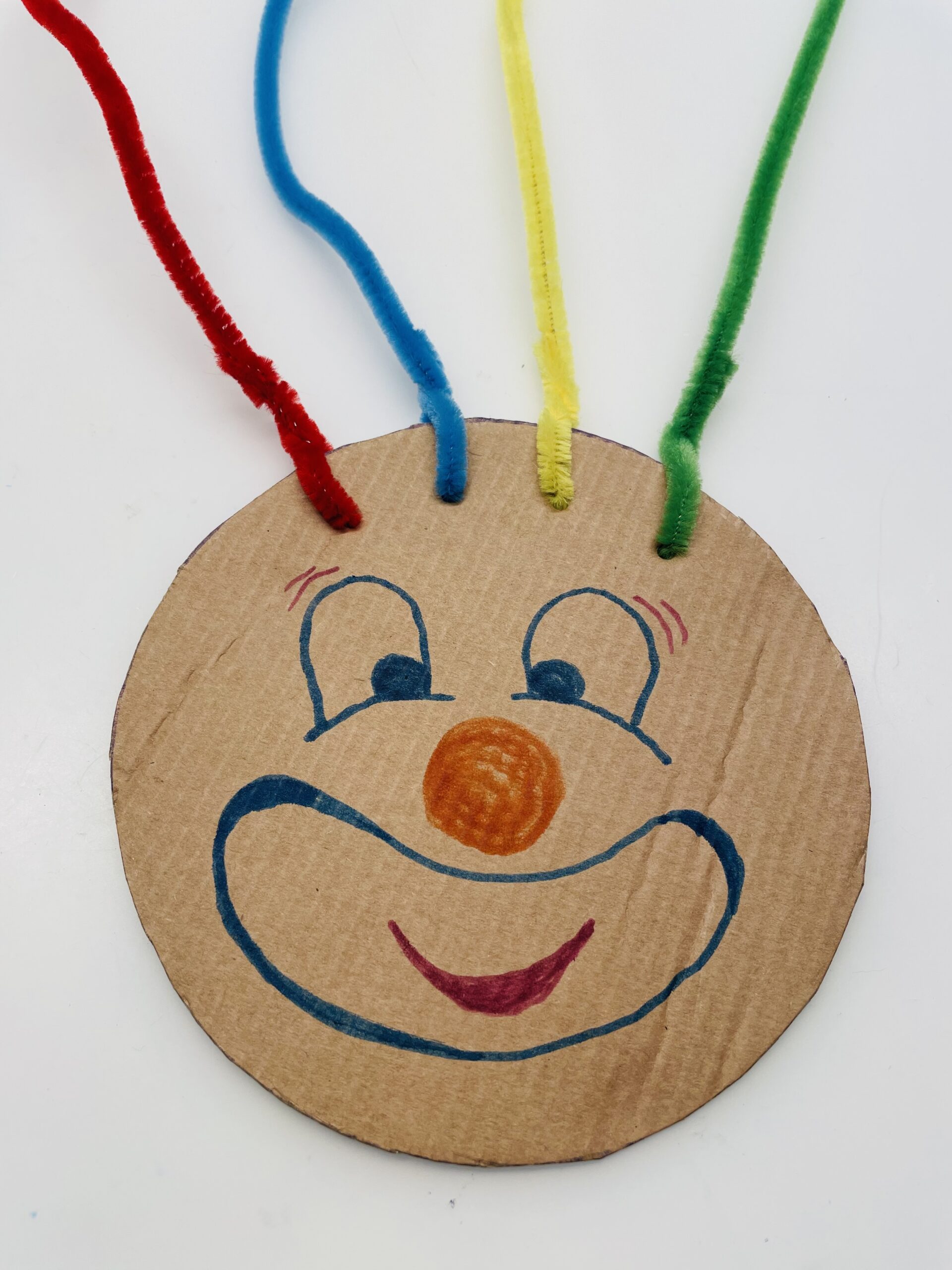 Bild zum Schritt 6 für das Bastel- und DIY-Abenteuer für Kinder: 'Jetzt malt ihr ein lustiges Clown-Gesicht auf den Kreis.'