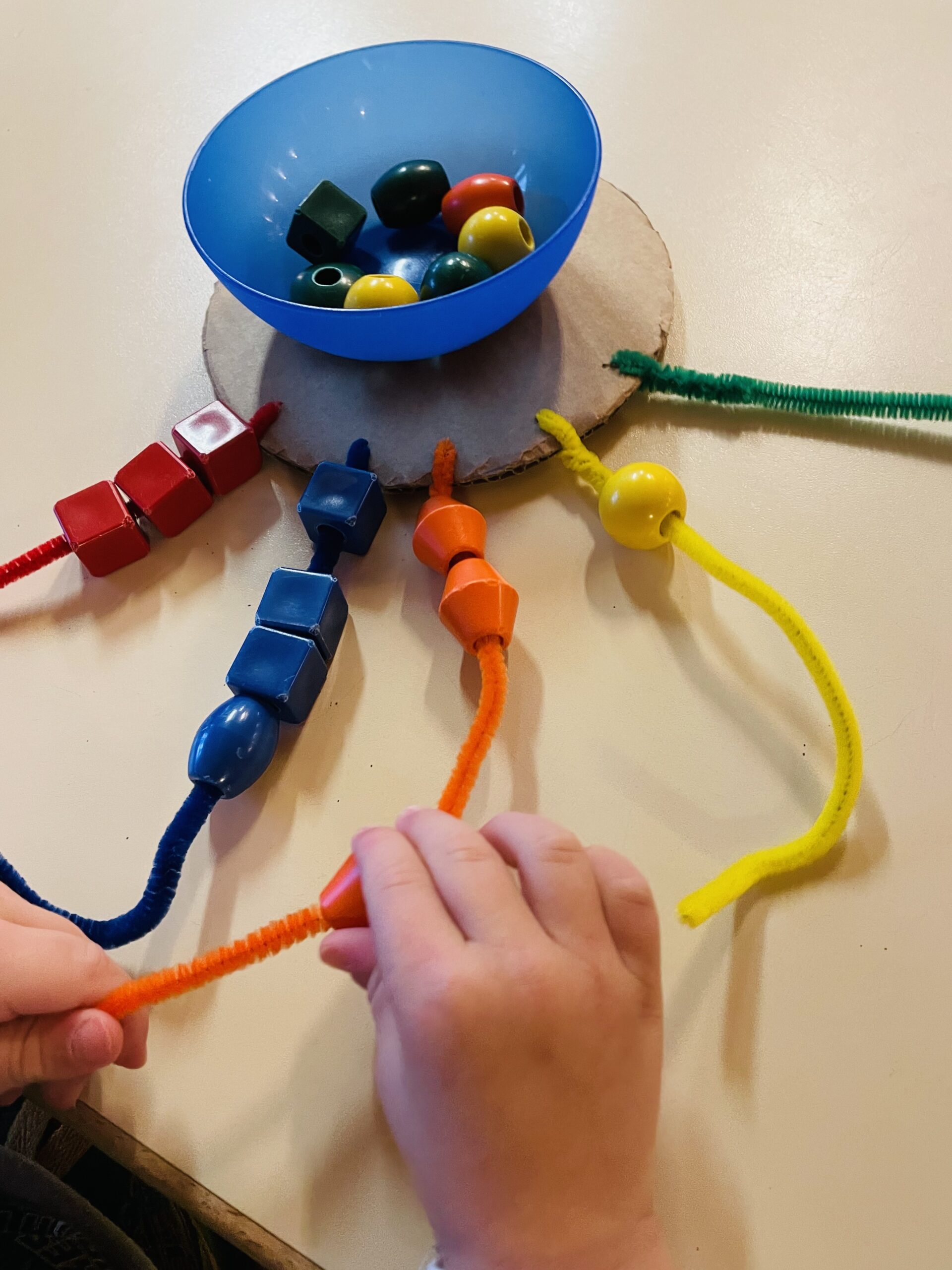 Bild zum Schritt 13 für das Bastel- und DIY-Abenteuer für Kinder: 'Stellt die Schüssel mit den Perlen auf den Kreis. Hier...'
