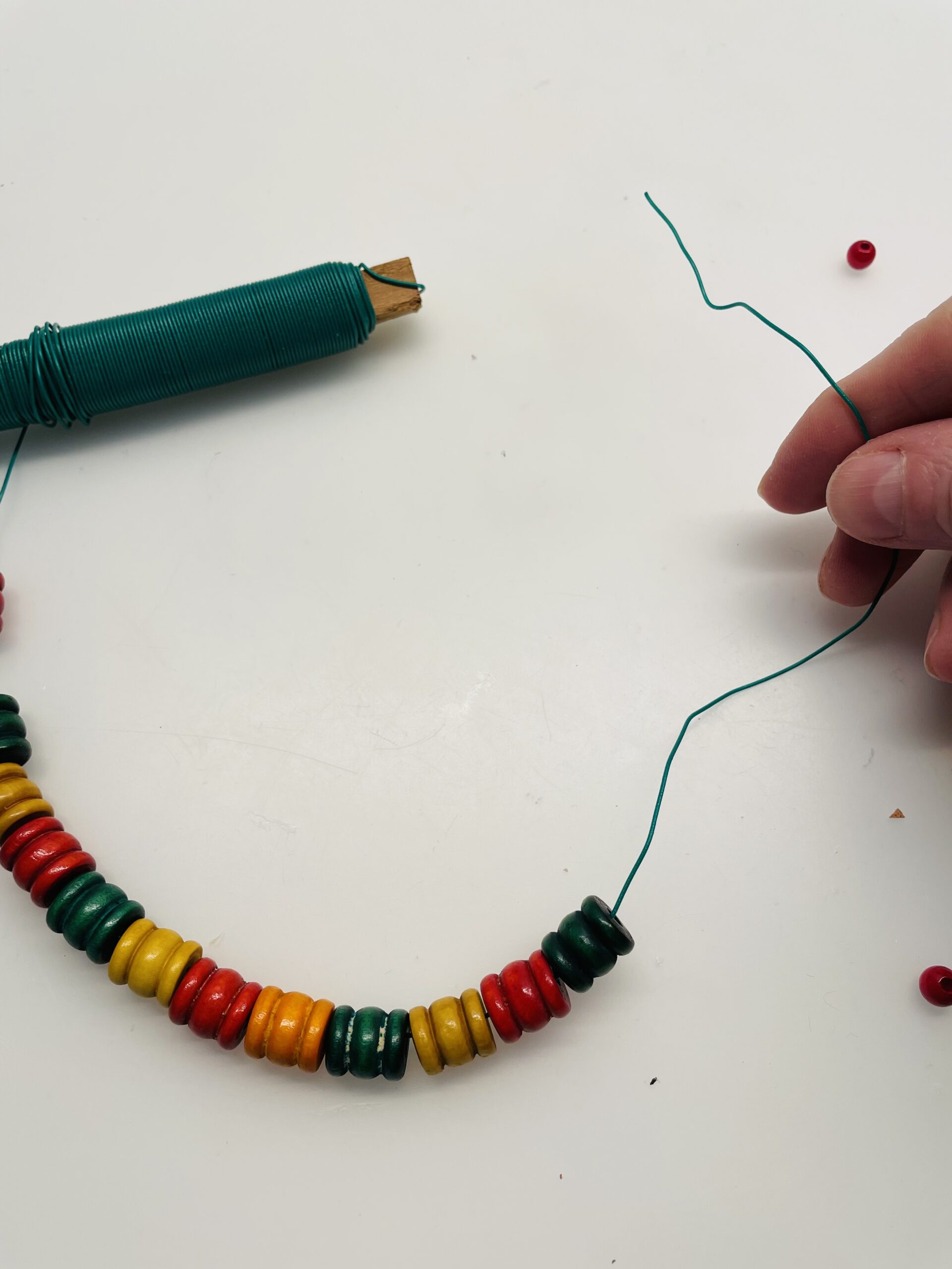 Bild zum Schritt 2 für das Bastel- und DIY-Abenteuer für Kinder: 'Nun fädelt ihr eure Perlen auf den Draht. Es sollten...'