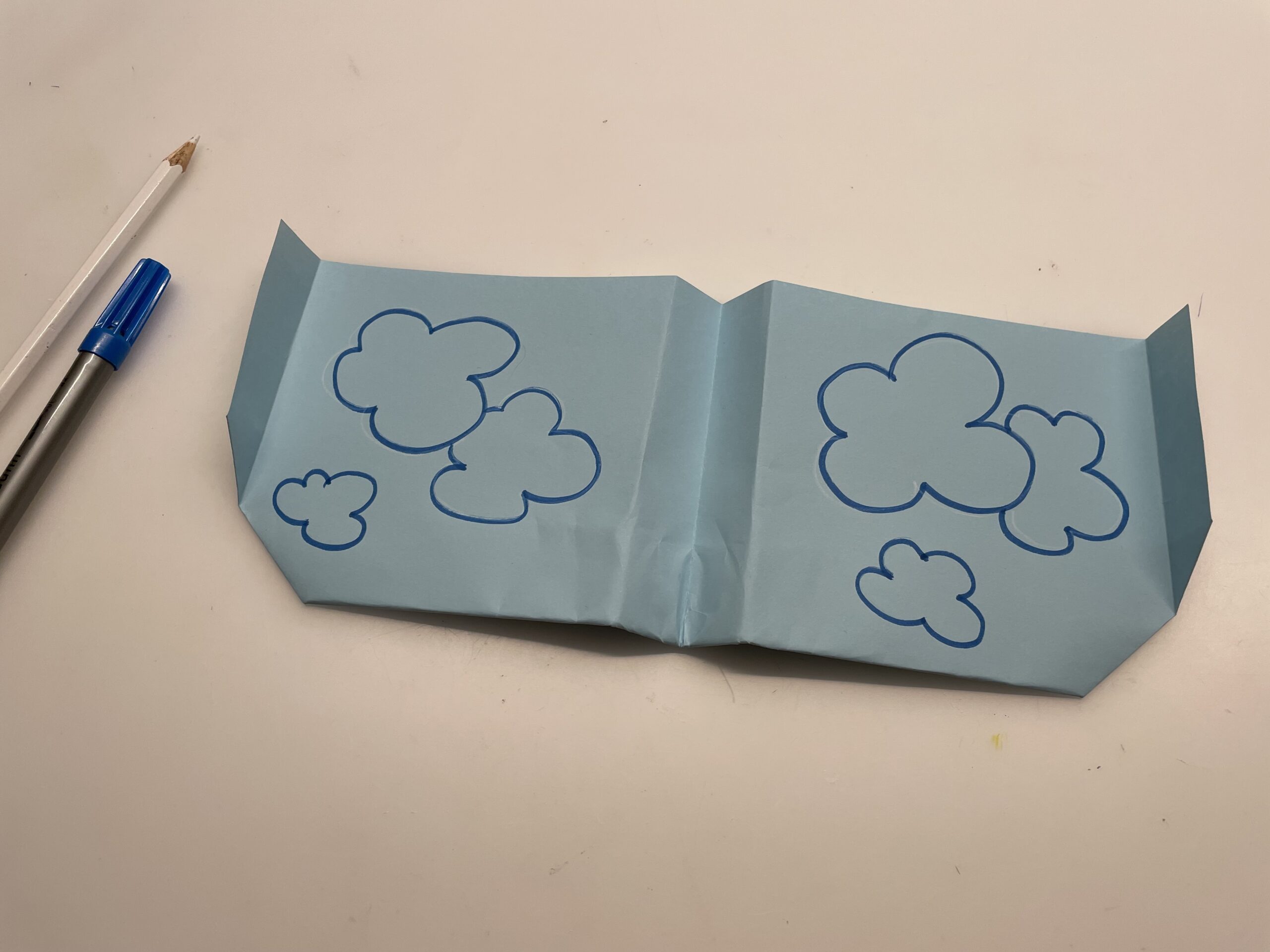 Bild zum Schritt 50 für das Bastel- und DIY-Abenteuer für Kinder: 'Malt Wolken auf die großen Tragflächen. Z.B. malt ihr mit...'