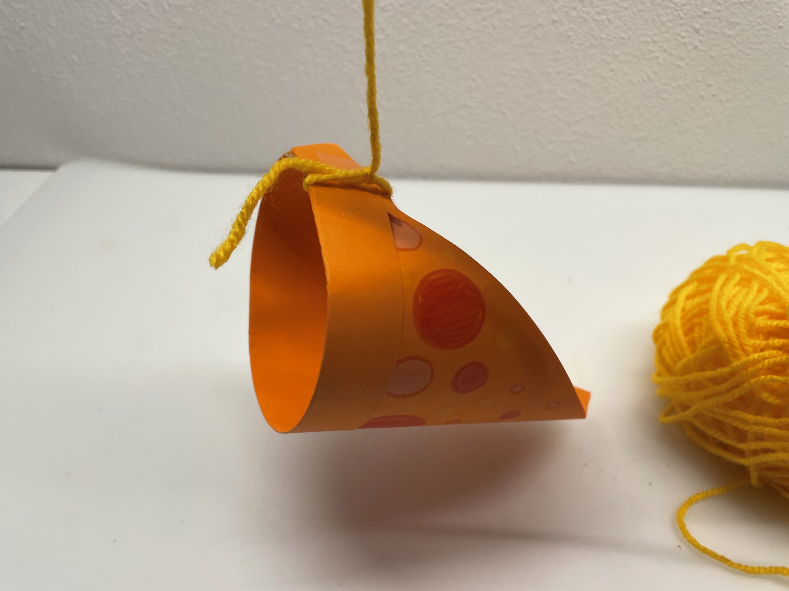 Bild zum Schritt 37 für das Bastel- und DIY-Abenteuer für Kinder: 'Anschließend schneidet ihr den Wollfaden ca. 50cm lang ab.'