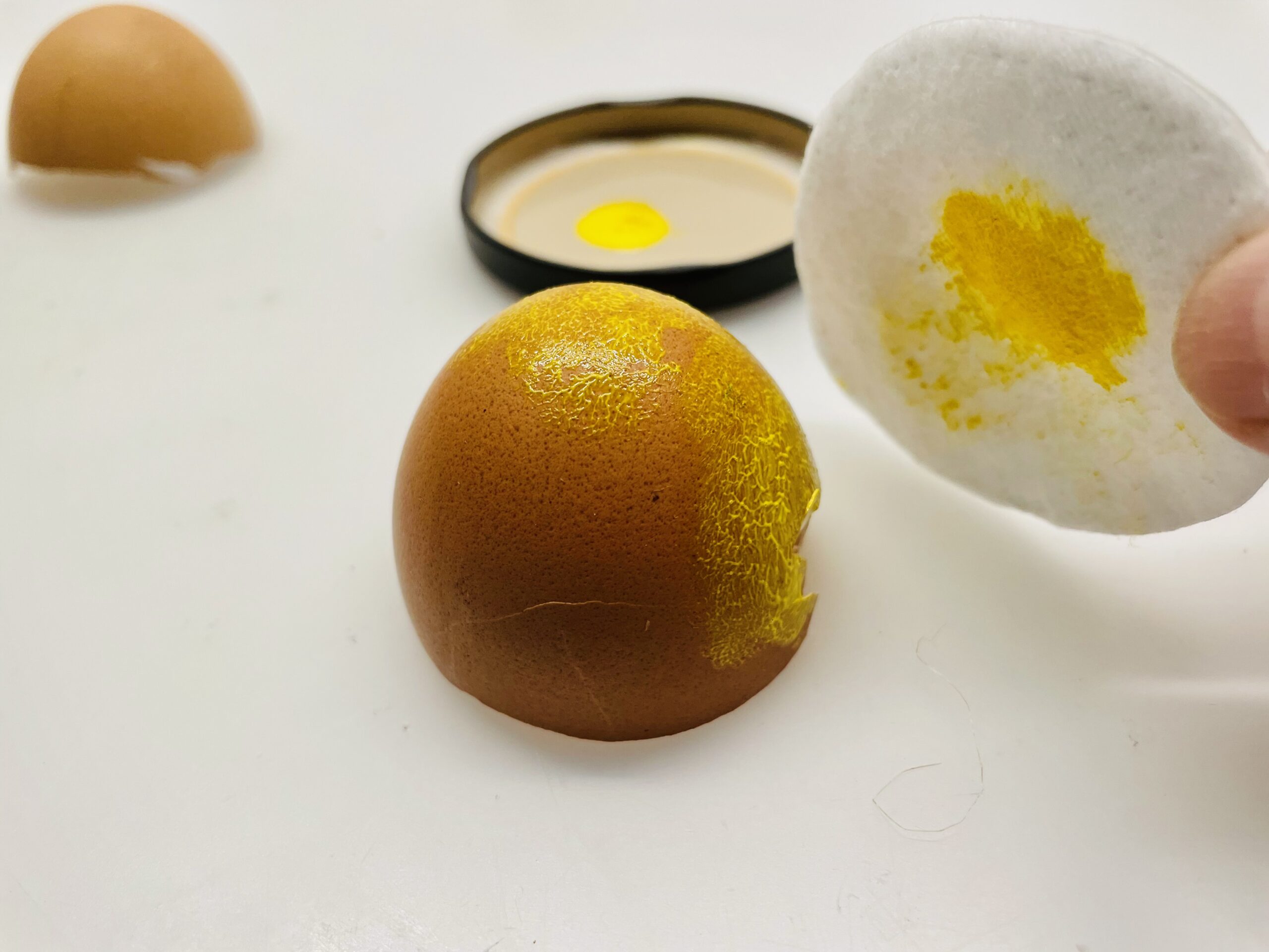 Bild zum Schritt 5 für das Bastel- und DIY-Abenteuer für Kinder: 'Nun tupft ihr die Farbe ganz vorsichtig auf die Eierschale.'
