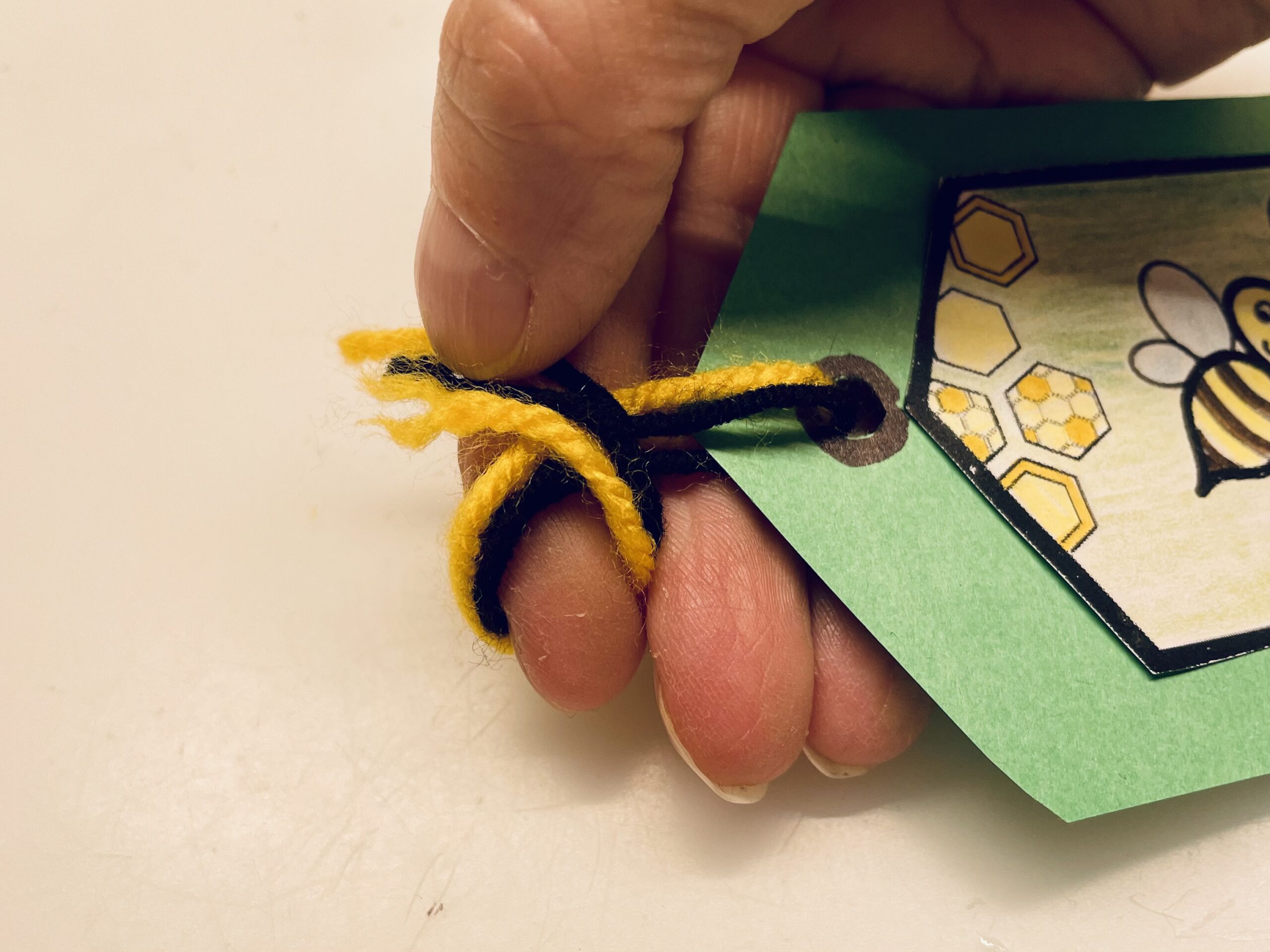 Bild zum Schritt 8 für das Bastel- und DIY-Abenteuer für Kinder: 'Dann legt ihr die Wollfäden als Schlaufe um euren Zeigefinger.'