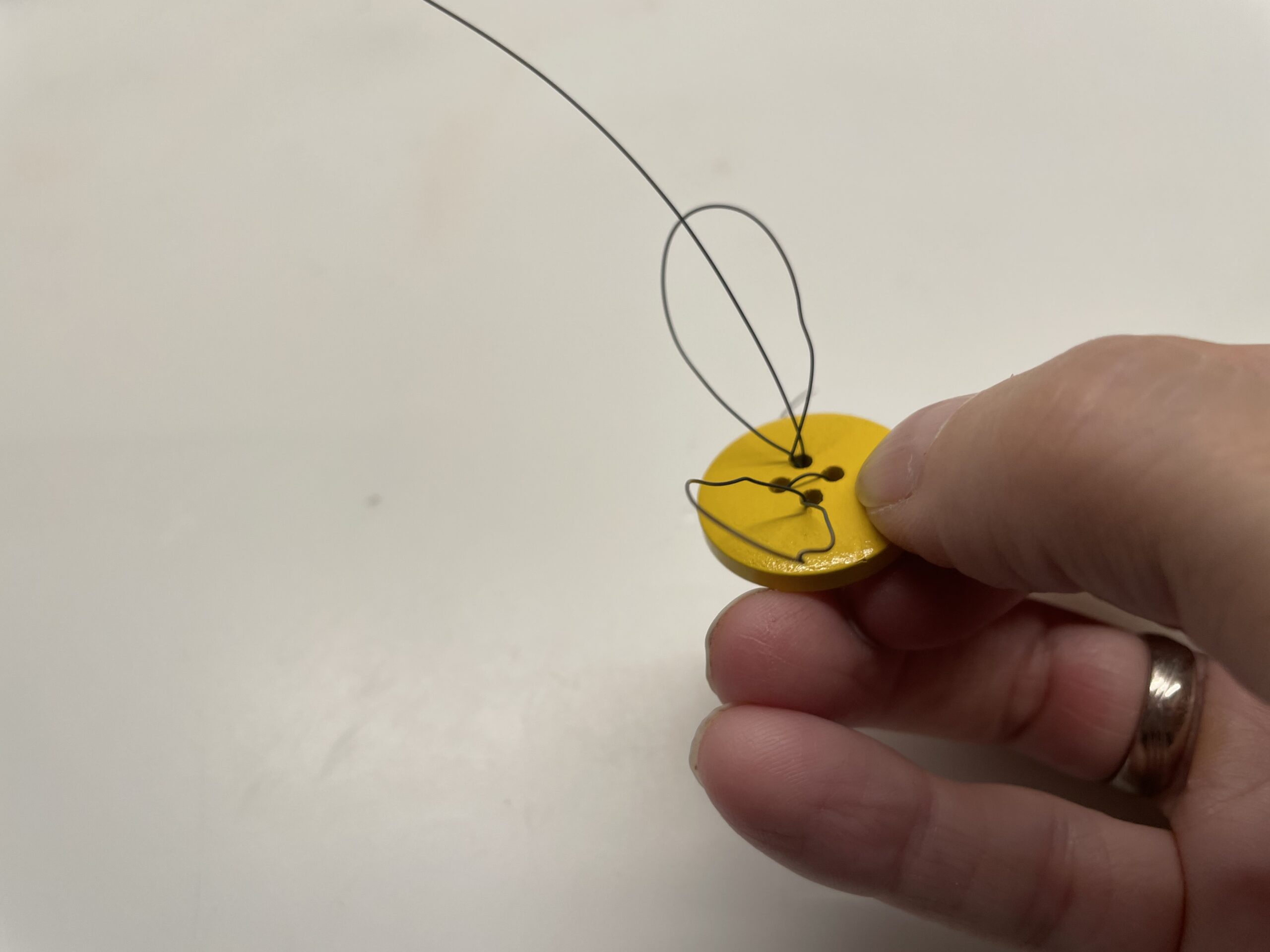 Bild zum Schritt 11 für das Bastel- und DIY-Abenteuer für Kinder: 'Greift den entstandenen Flügel mit einer Hand und dreht ihn...'