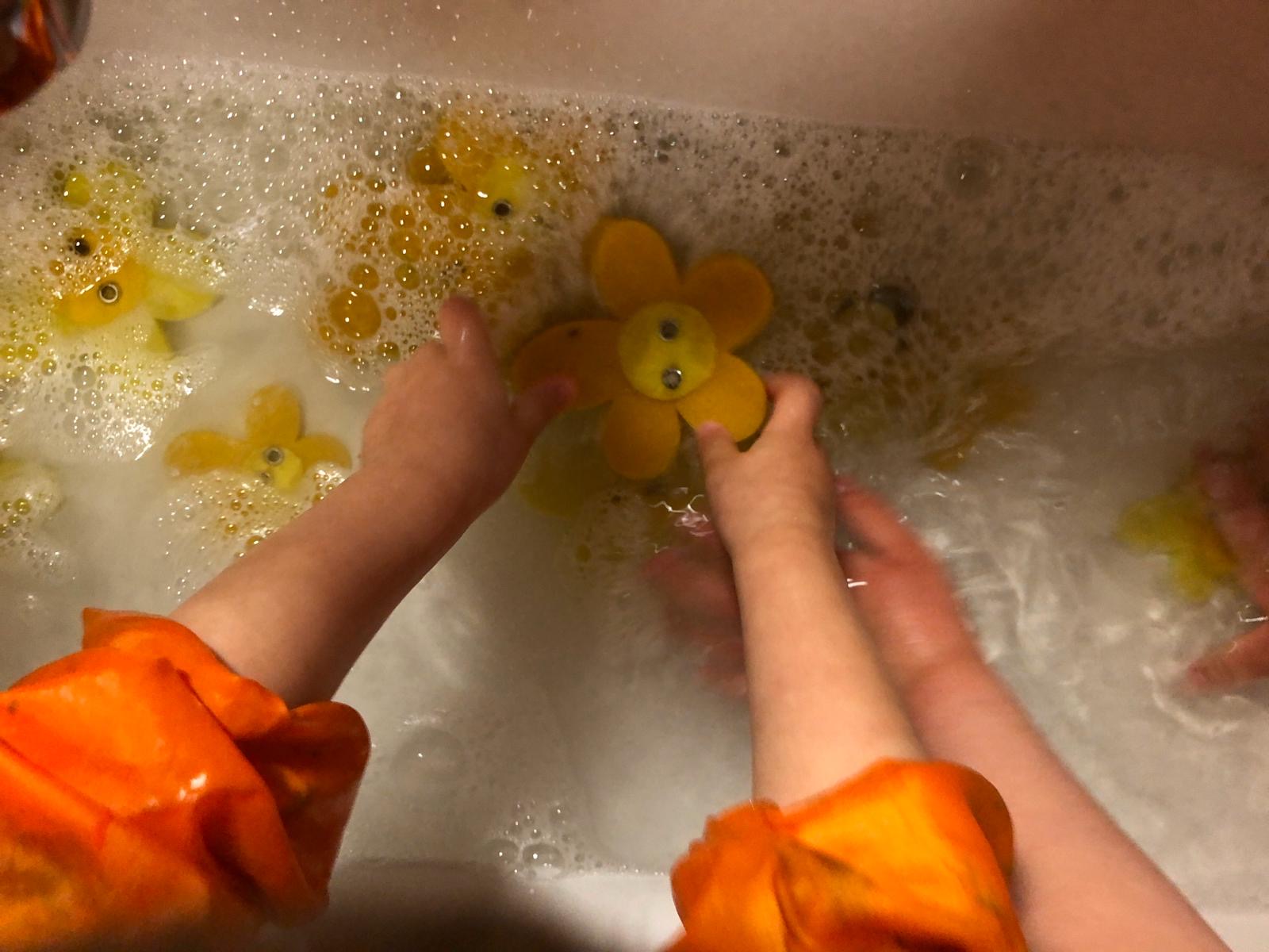 Bild zum Schritt 2 für das Bastel- und DIY-Abenteuer für Kinder: 'Die Kinder legen die Filzblumen hinein und waschen sie vorsichtig.'