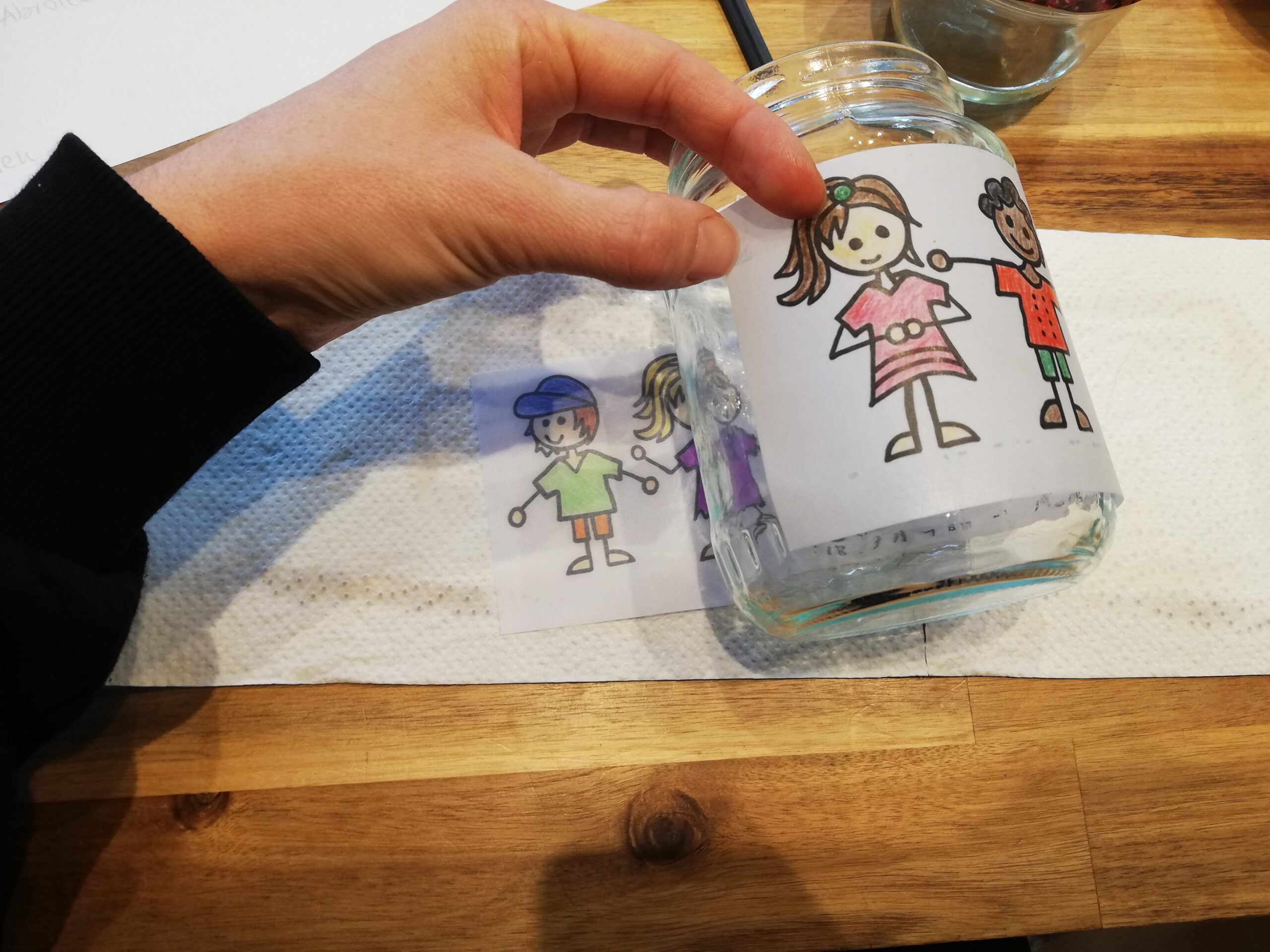 Bild zum Schritt 12 für das Bastel- und DIY-Abenteuer für Kinder: '[Eltern]Jetzt legt ihr die Banderole um das Glas und fixiert...'