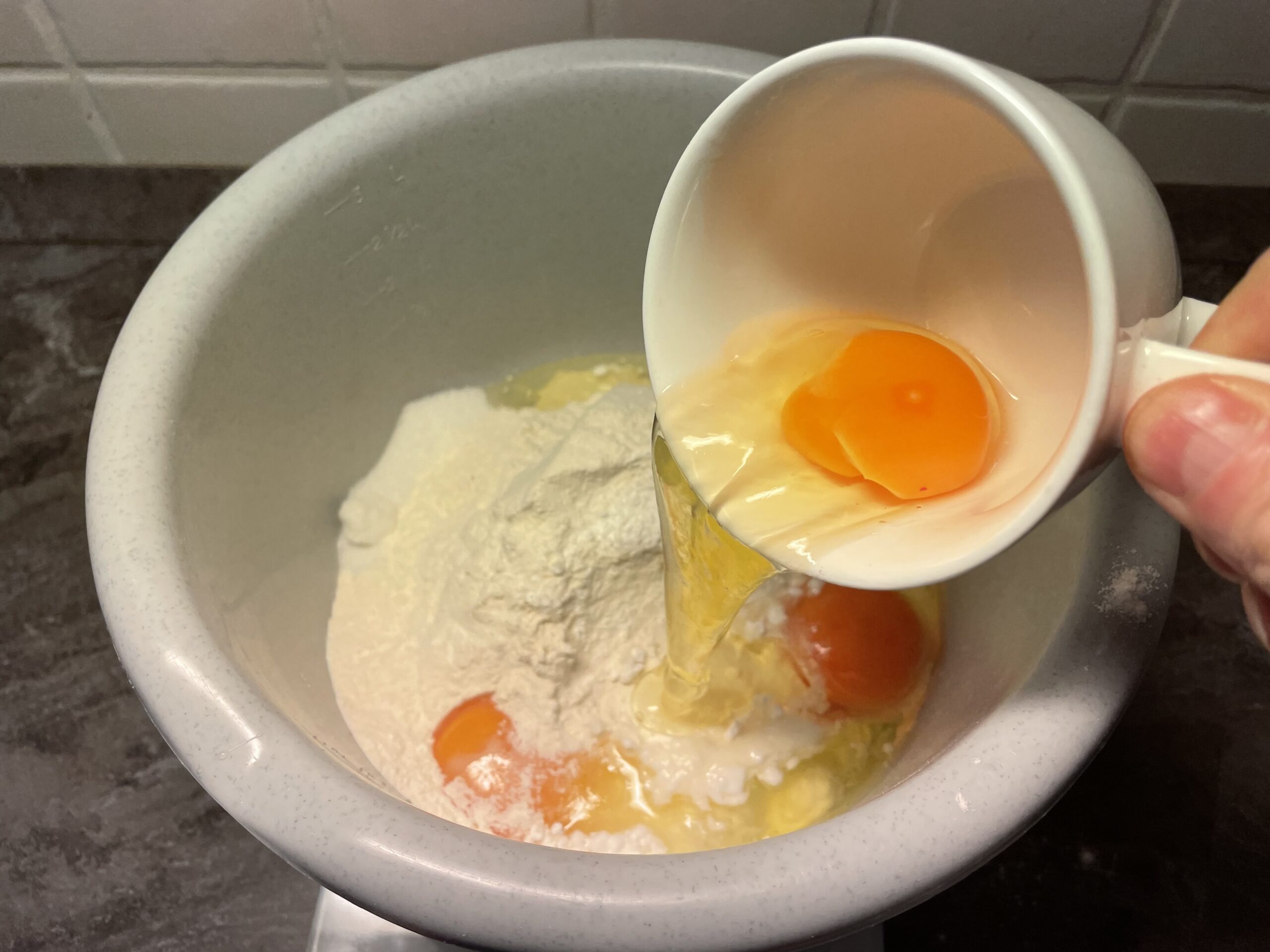 Bild zum Schritt 11 für das Bastel- und DIY-Abenteuer für Kinder: 'Schlagt jedes Ei einzeln in die Tasse auf und gebt...'