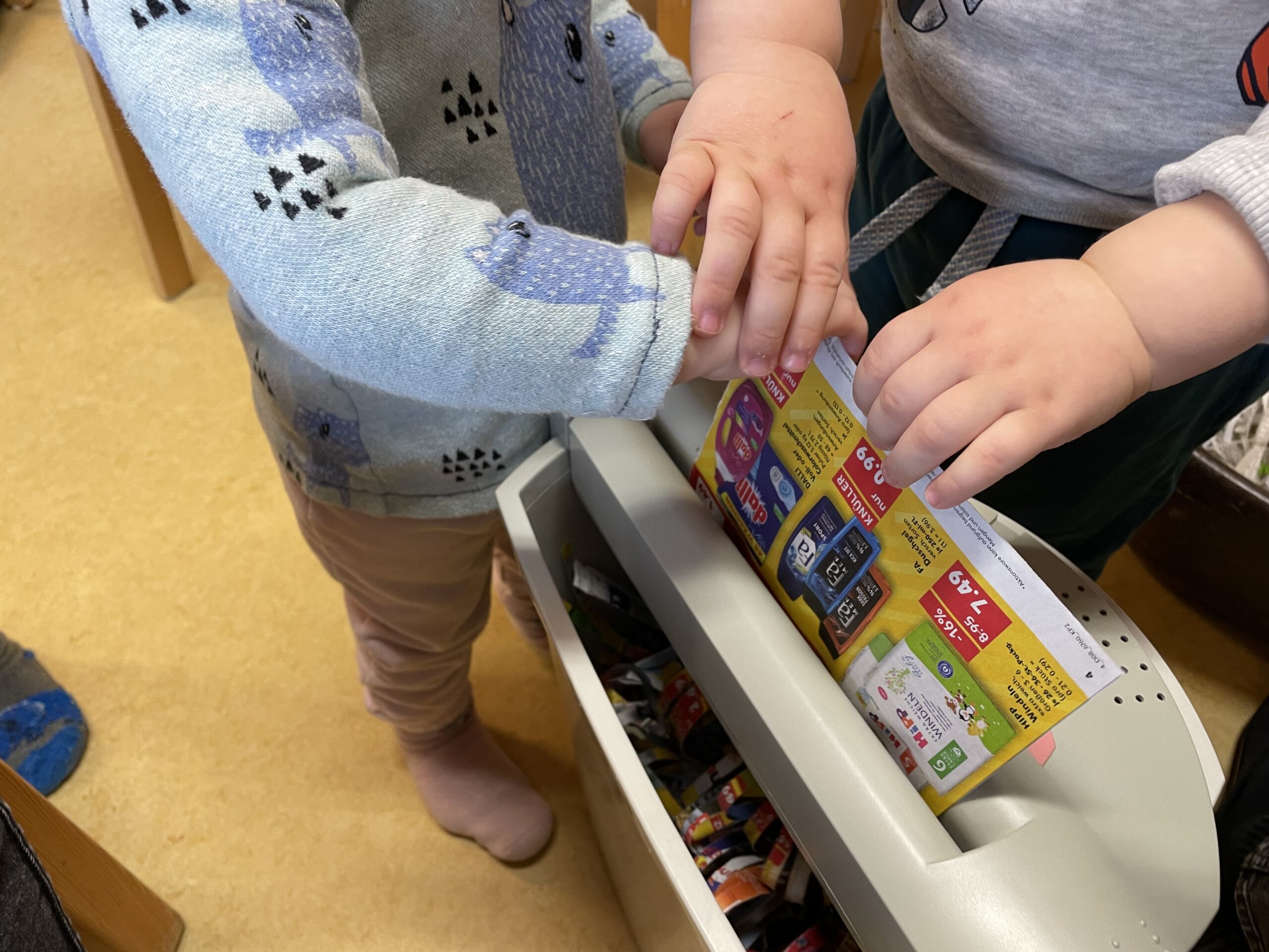 Bild zum Schritt 20 für das Bastel- und DIY-Abenteuer für Kinder: 'Nehmt einen Papierschredder und Werbeprospekte. Schreddert diese.'
