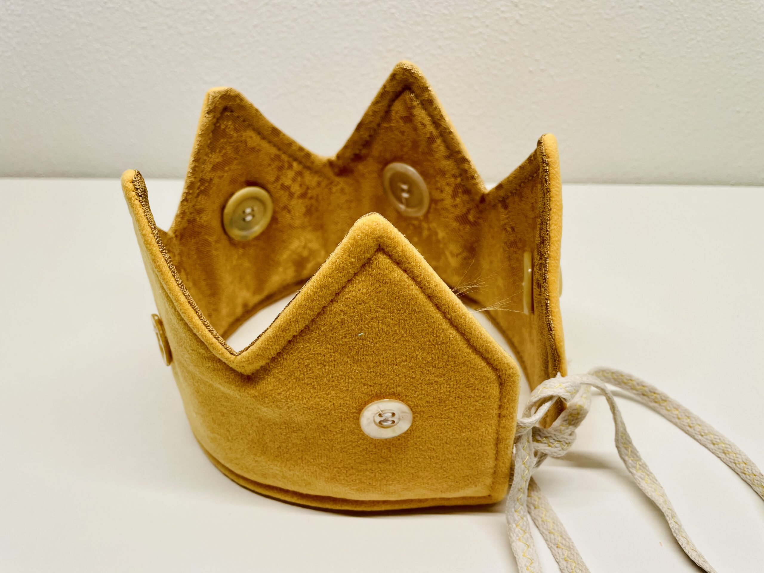 Bild zum Schritt 61 für das Bastel- und DIY-Abenteuer für Kinder: 'Mit den Bändern könnt ihr die Krone zusammenbinden und aufsetzen.'