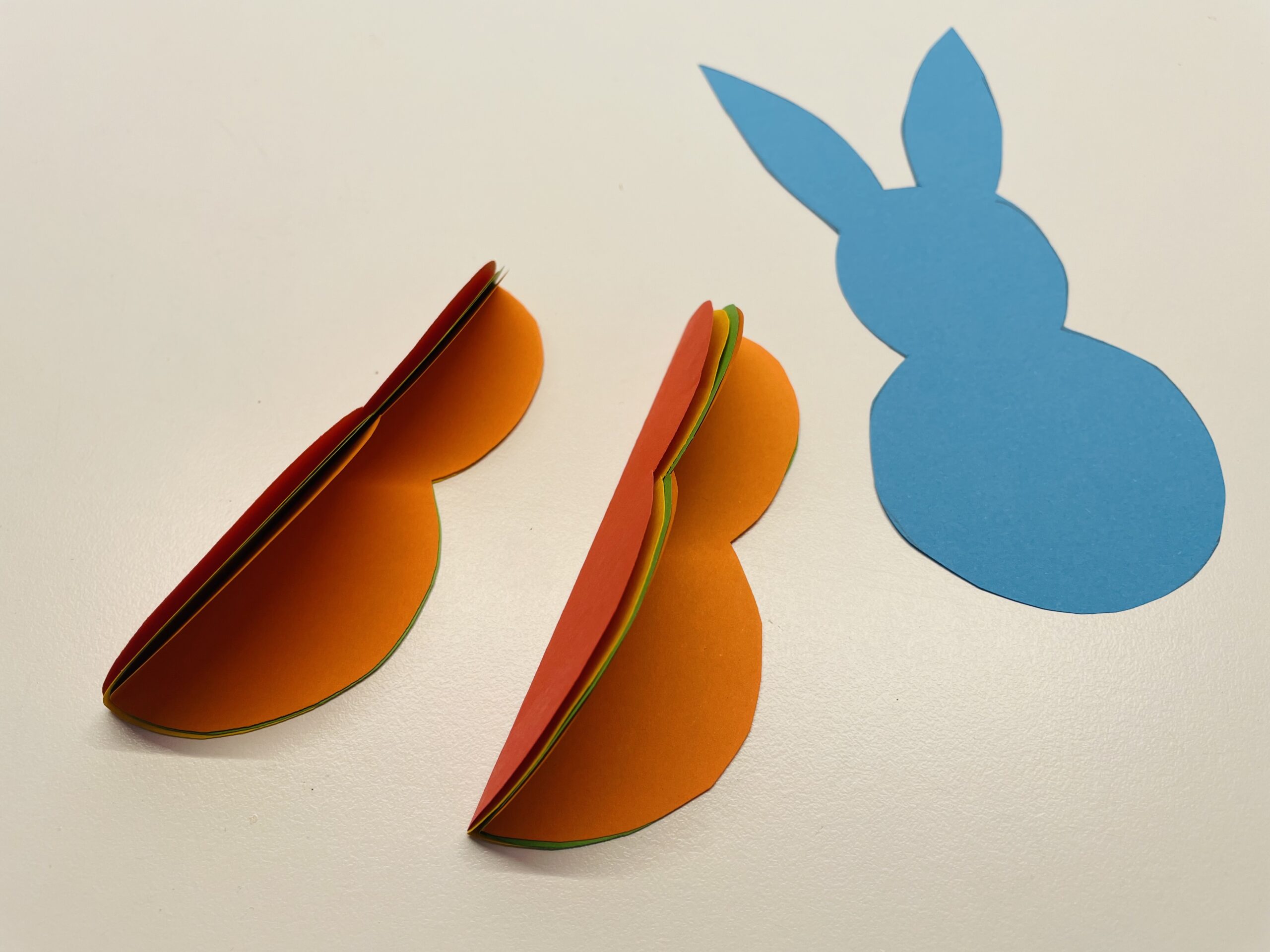 Bild zum Schritt 11 für das Bastel- und DIY-Abenteuer für Kinder: 'Der Hase mit Ohren (hier in blau) wird als Mittelteil...'