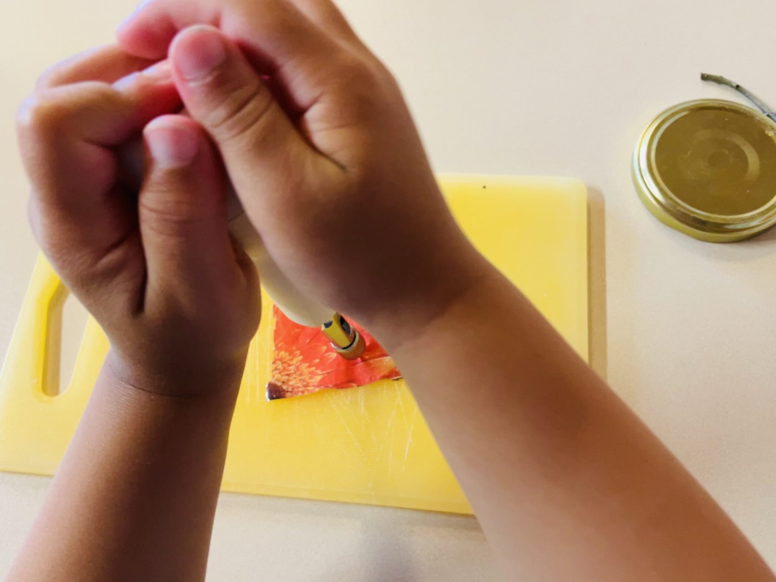 Bild zum Schritt 8 für das Bastel- und DIY-Abenteuer für Kinder: 'Jetzt legt ihr das Folienstück auf ein Brett und macht...'